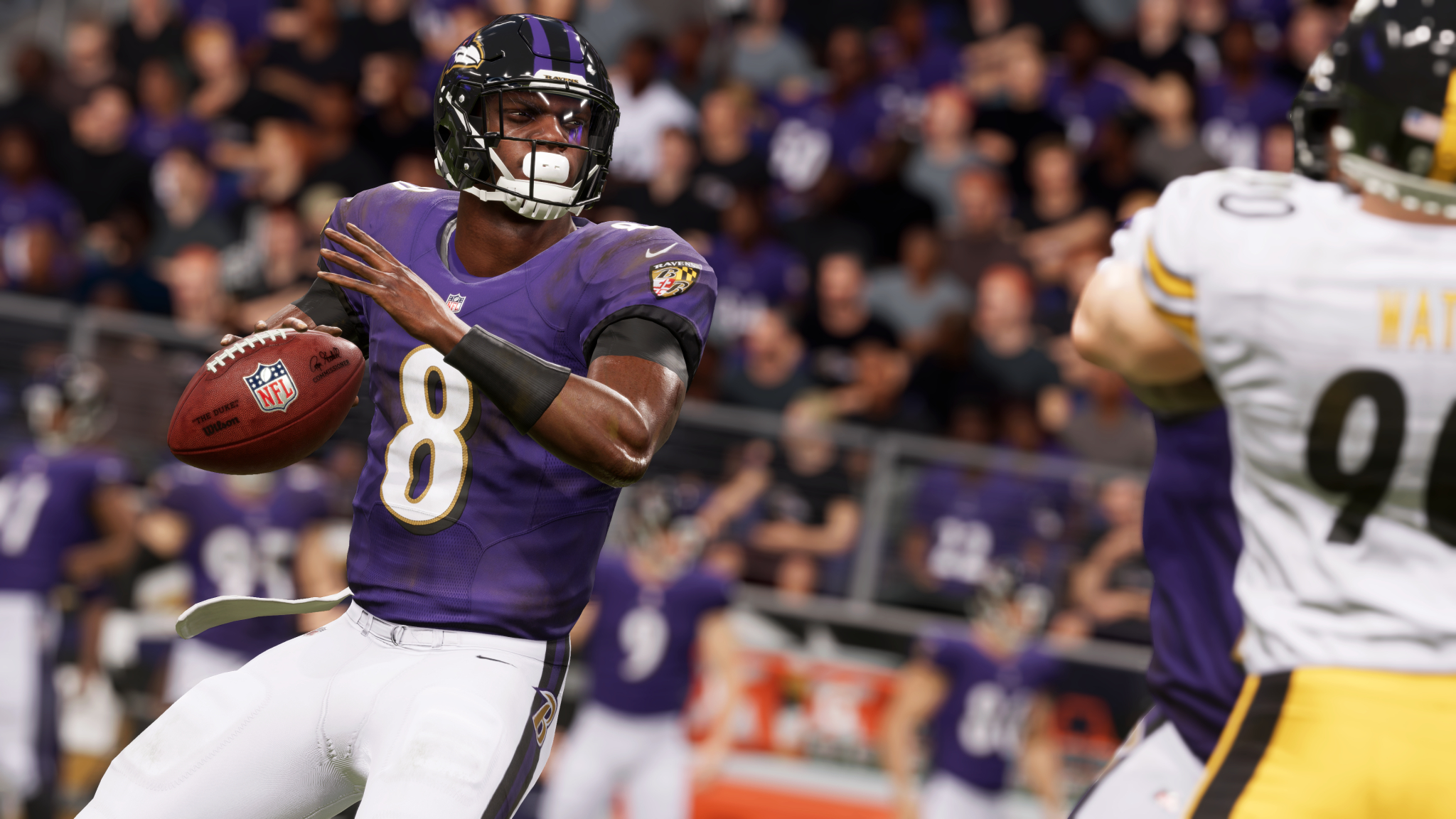 American footballspeler in een paars Ravens-shirt gooit een bal. Een andere speler op de achtergrond.
