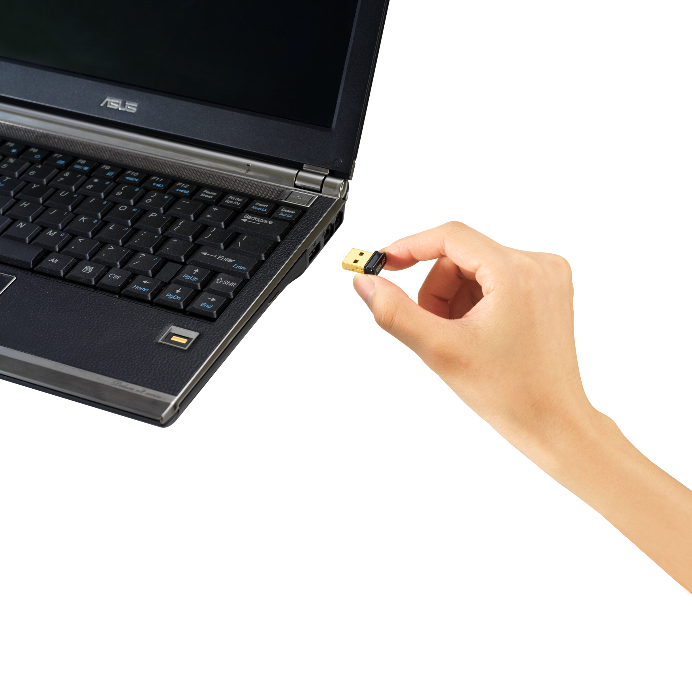 Kéz USB vevőt tart laptop mellett. Fekete háttér.
