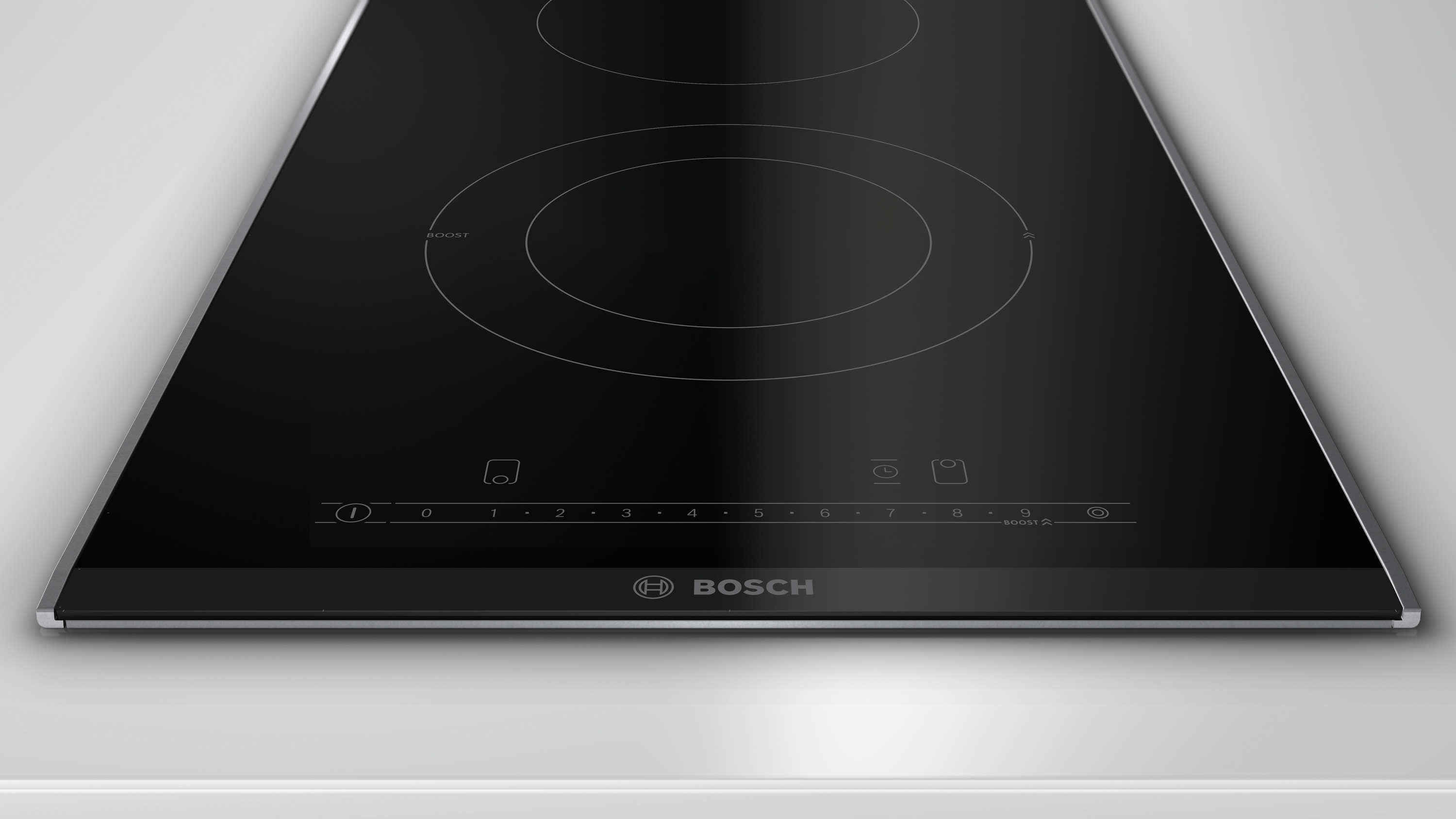 Schwarzes Induktionskochfeld. Das Bosch-Logo ist sichtbar. Knöpfe und Touch-Bedienelemente sind vorhanden.