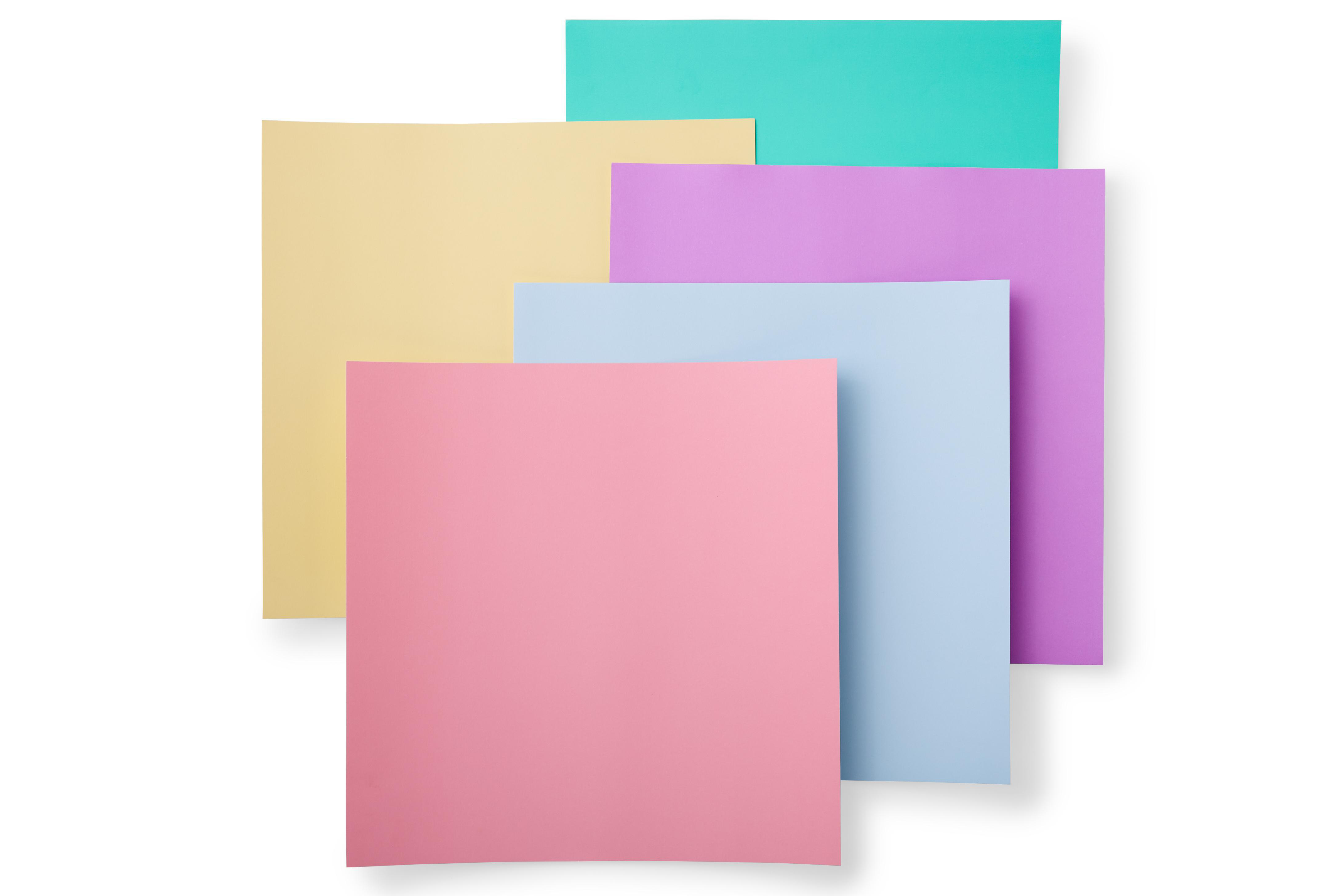 Überlappende Papiere in Pastellfarben: rosa, blau, lila, gelb und türkis. Der Hintergrund ist weiß.