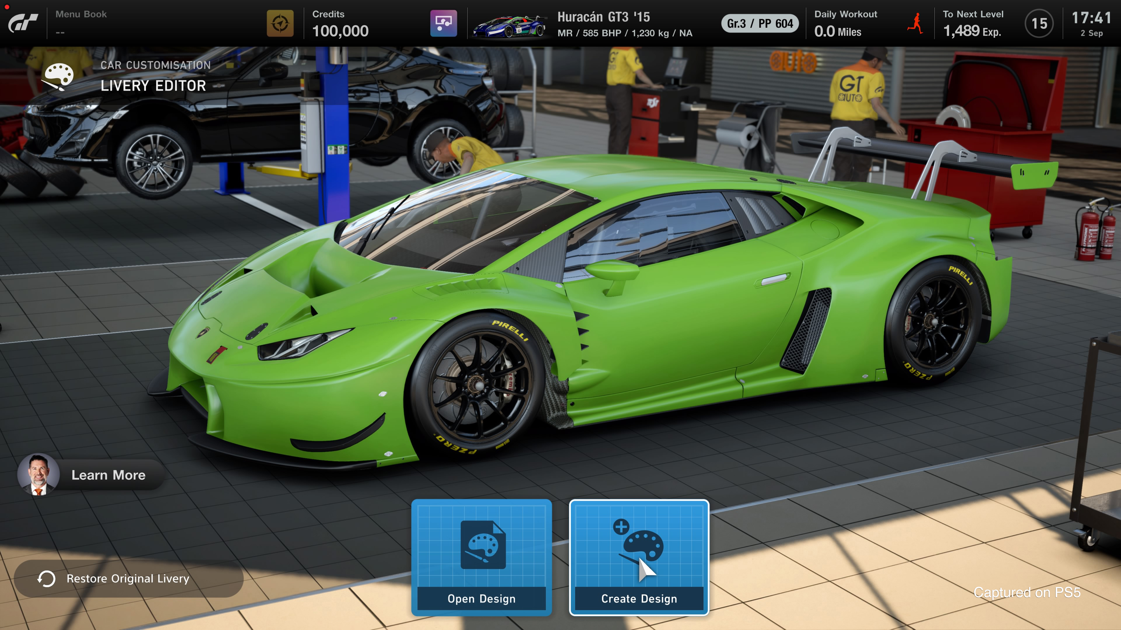 A lime green sports car inside a garage. A man is working on a car.
