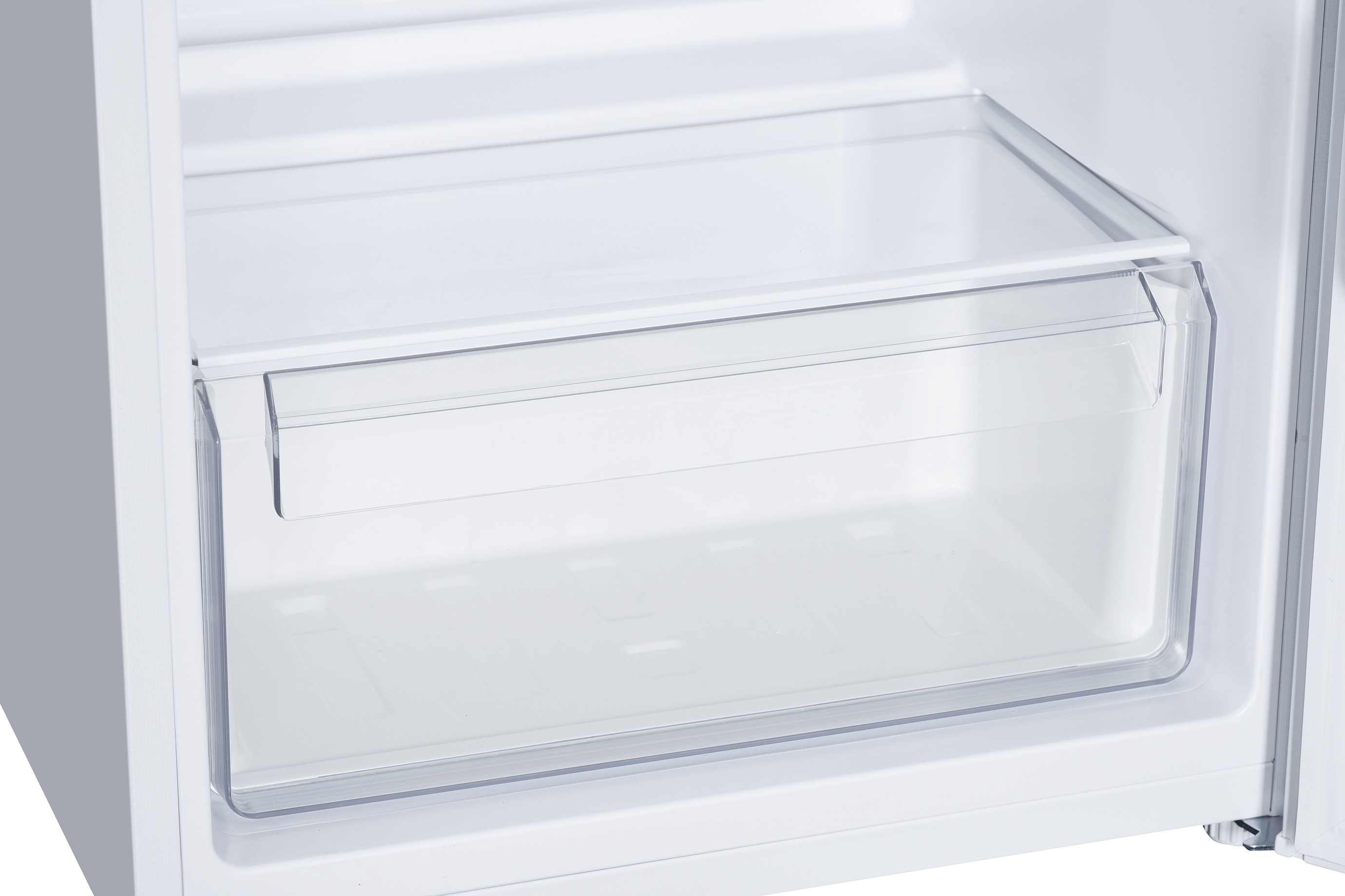 In einem weißen Kühlschrank ist eine transparente Gemüseschublade zu sehen. Die Kühlschranktür ist ebenfalls weiß. Die Szene ist hell.
