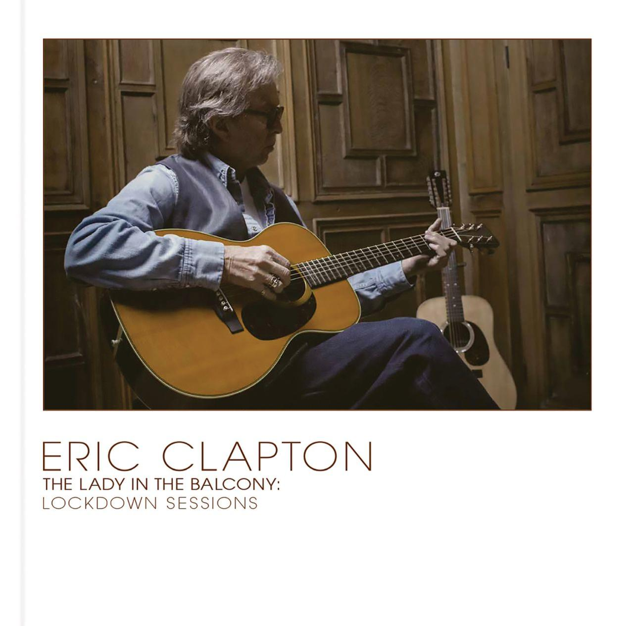 Eric Clapton gitározik. Ül. A háttérben fapanelokkal borított szoba látható.
