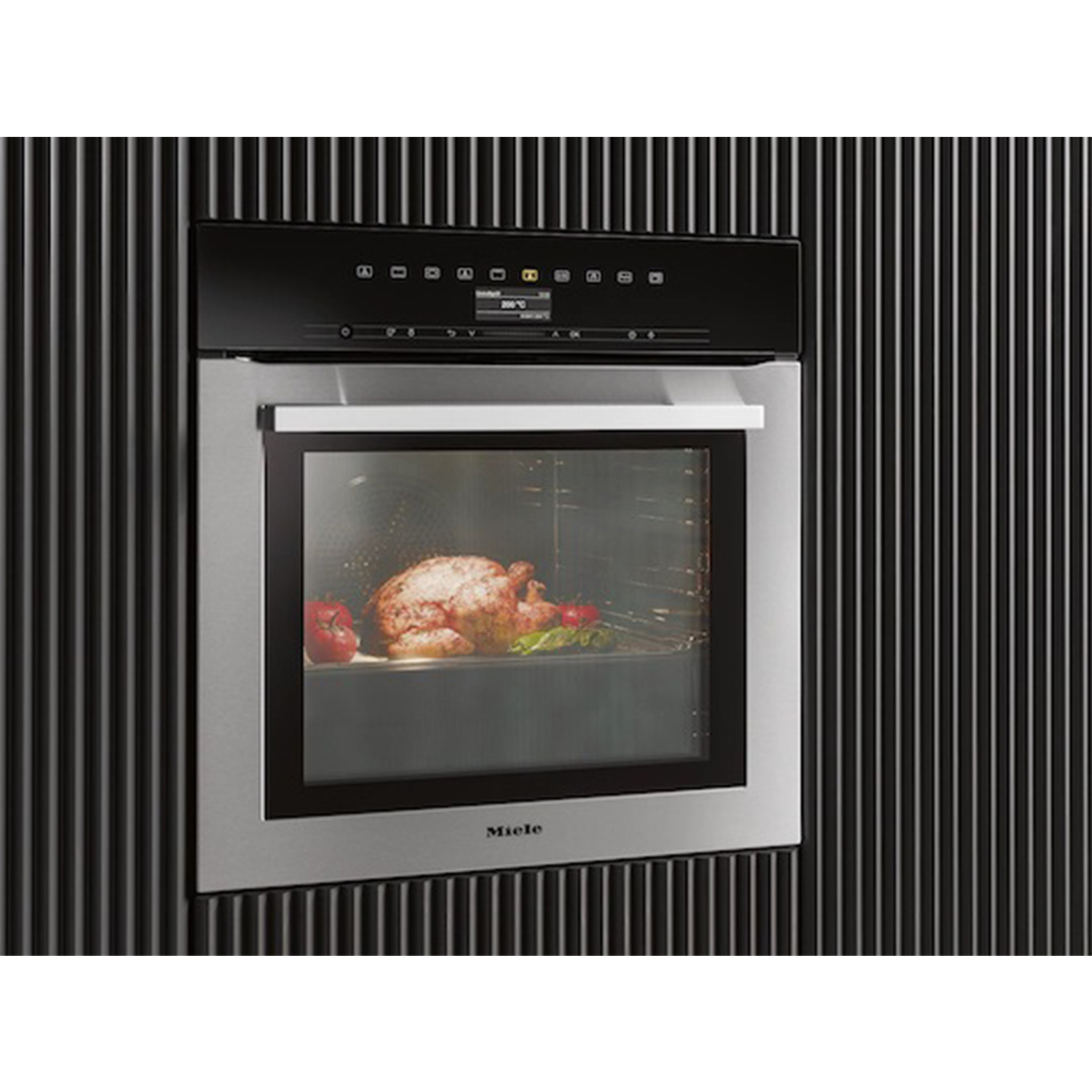 Forno a incasso con pollo cotto e verdure visibili attraverso la porta a vetro. Nero e argento.