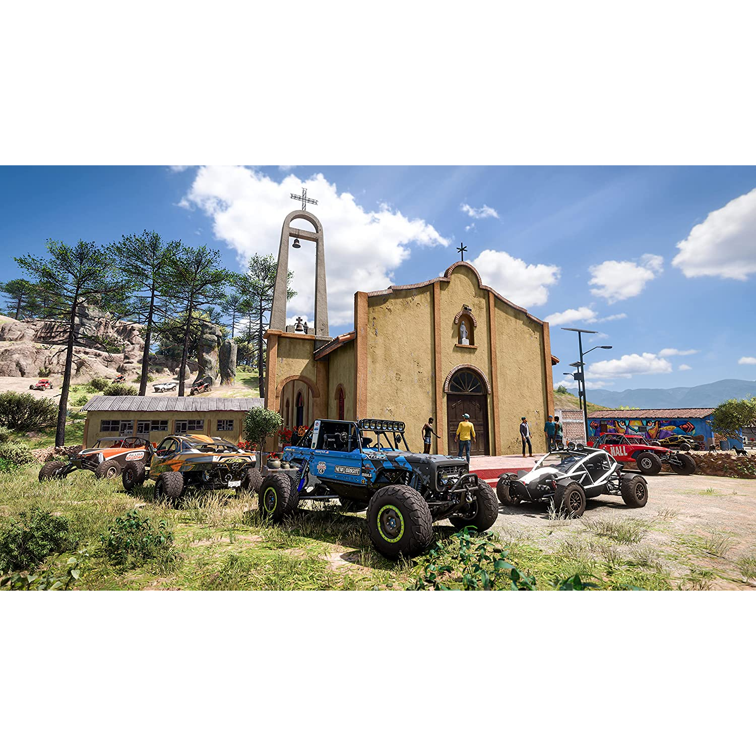 Vehículos todoterreno están estacionados cerca de una iglesia. El cielo es azul y el sol brilla.