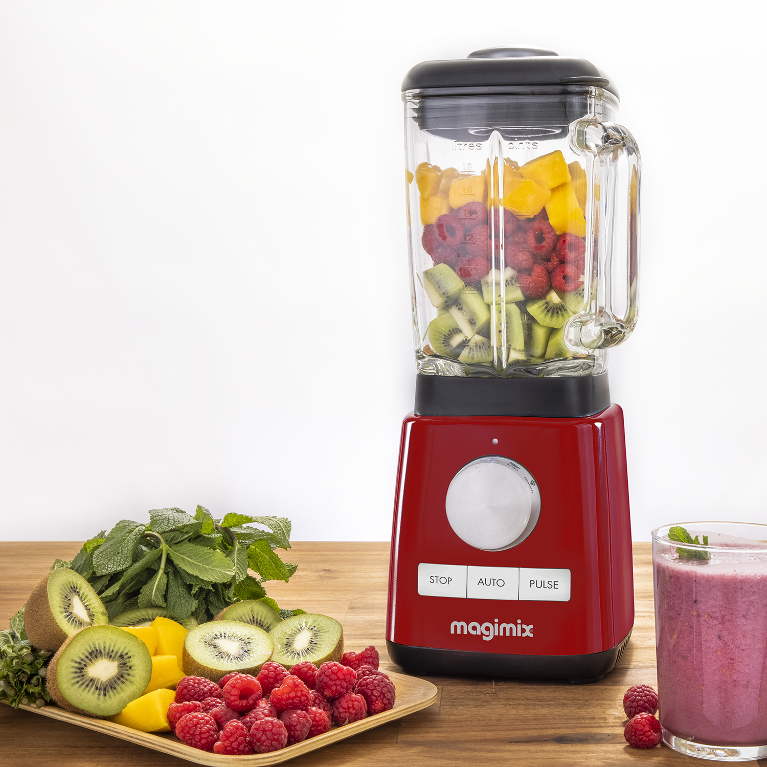 Een blender met fruit erin en ernaast.