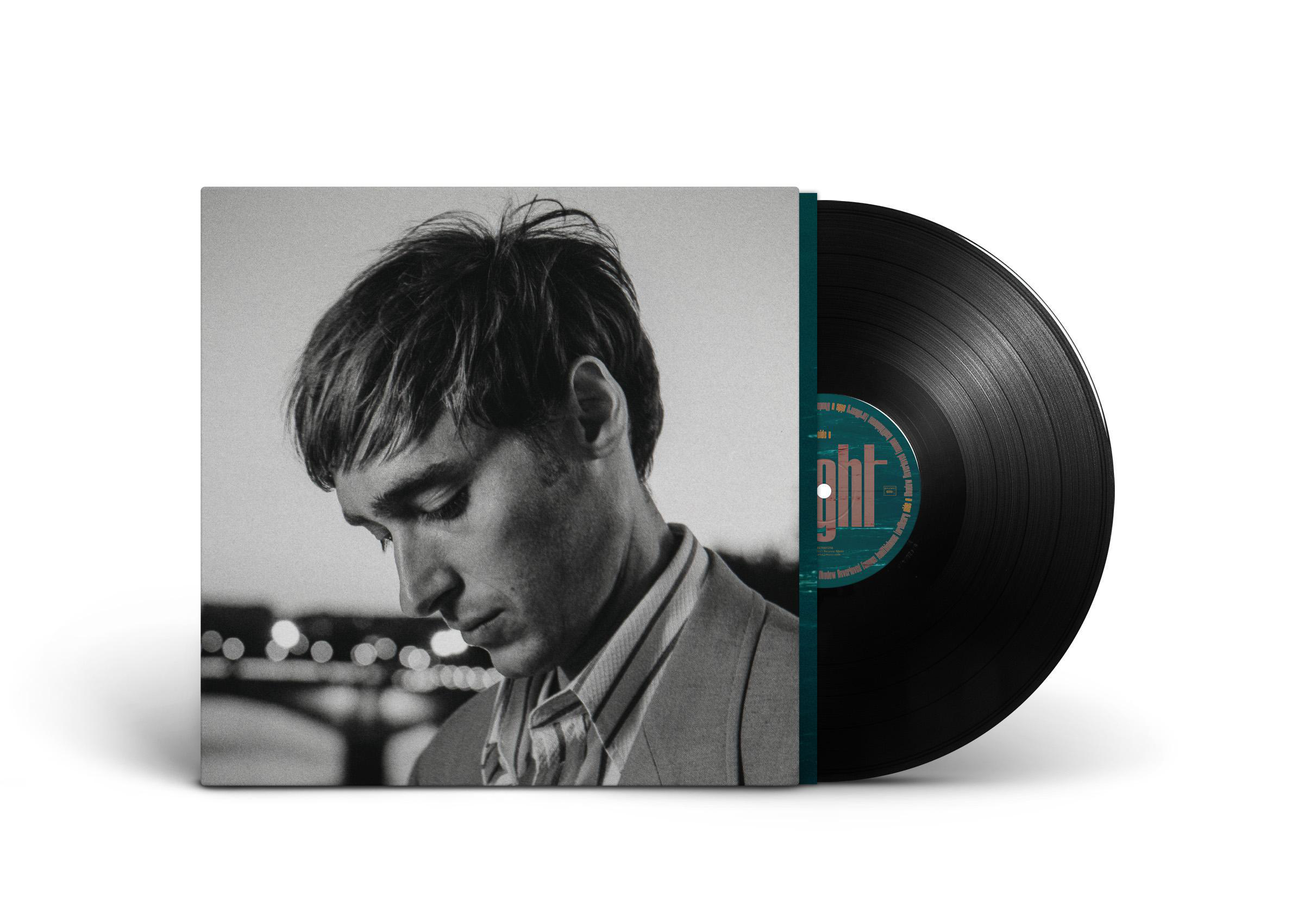 Albumcover eines Mannes, der nach unten schaut, mit Albumtitel und Vinyl-Schallplatte.