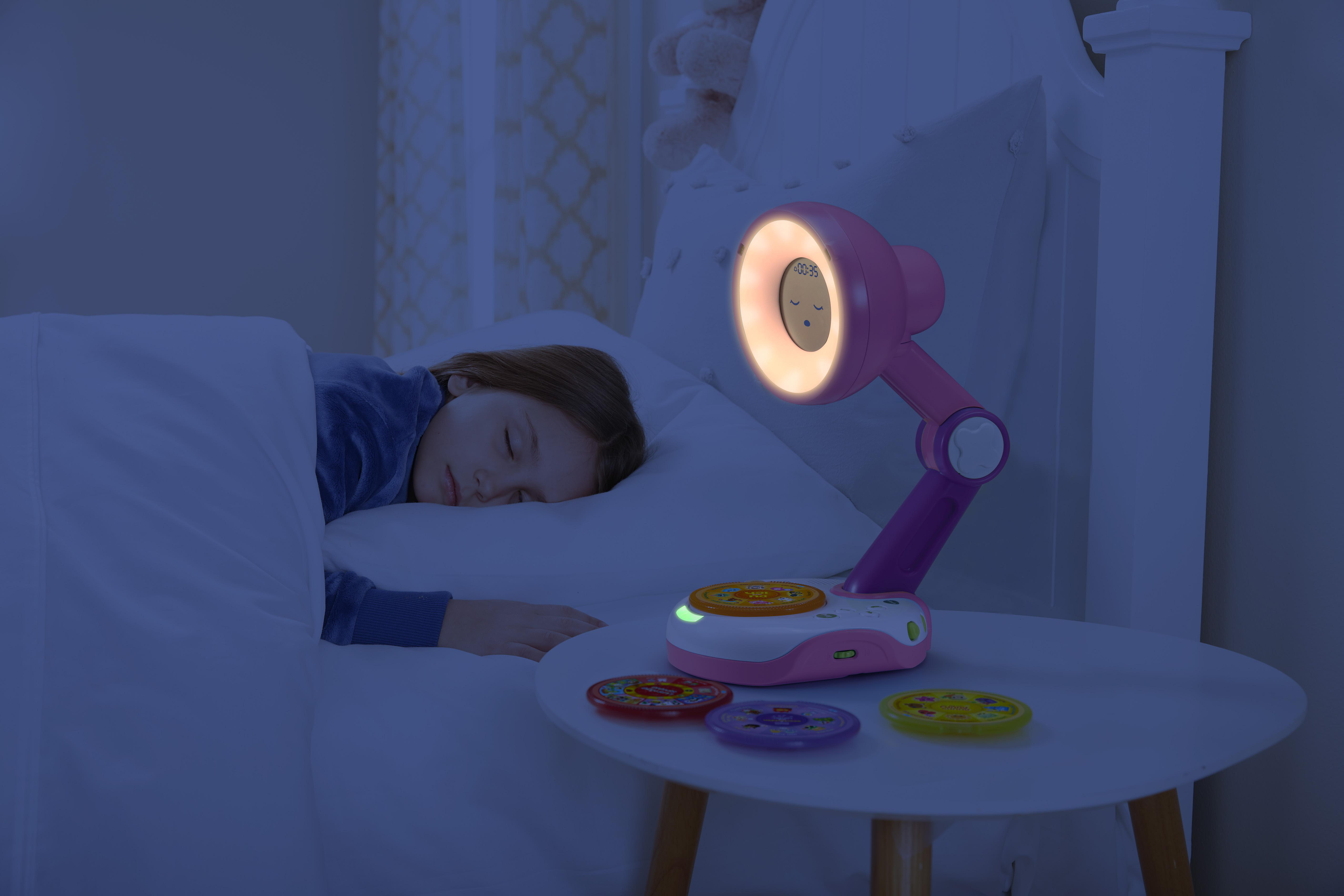 Ein Mädchen schläft in einem Bett neben einer pinkfarbenen Nachttischlampe.