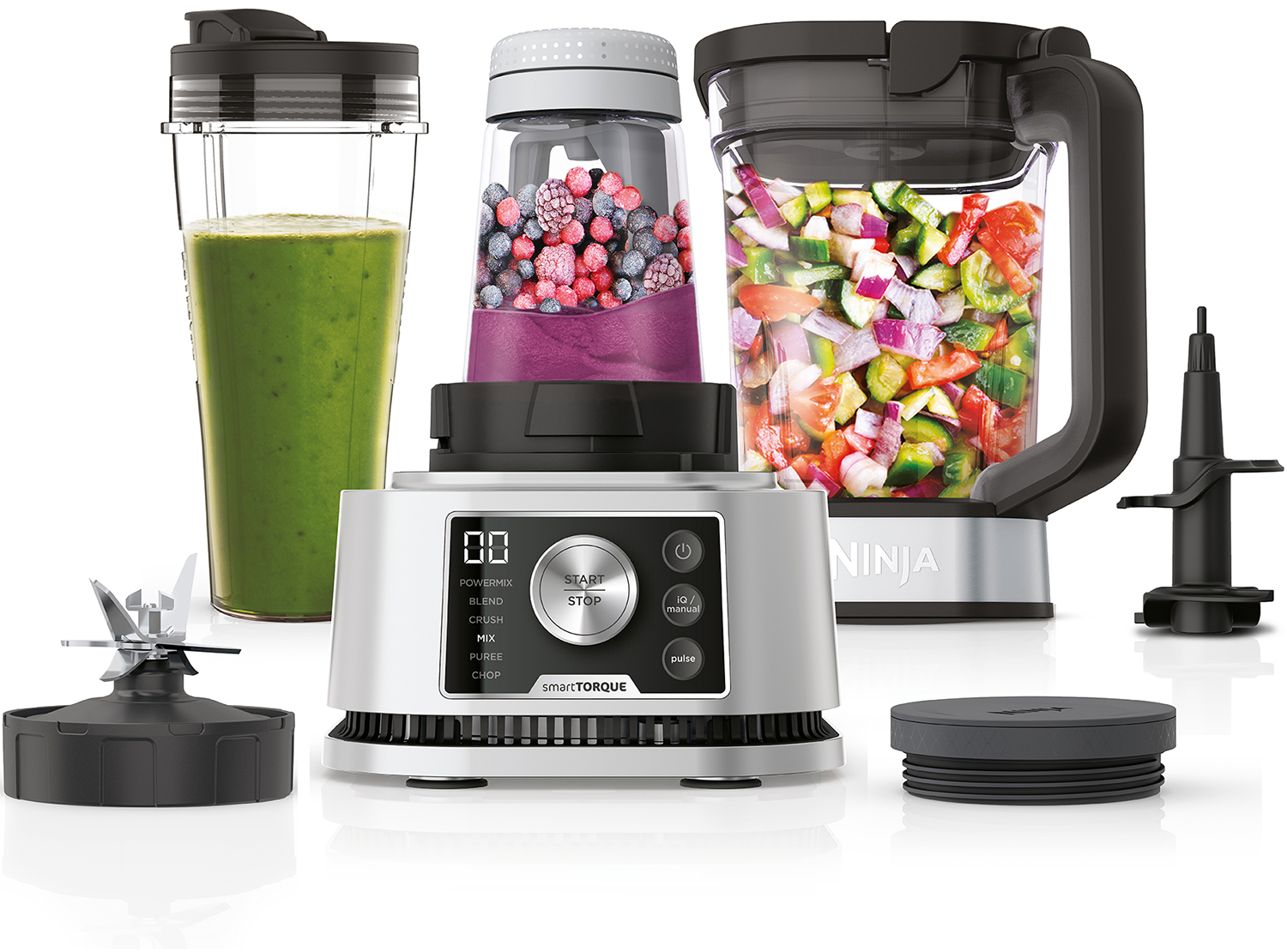 Een Ninja-blender met meerdere containers en hulpstukken, met een groene smoothie erin.