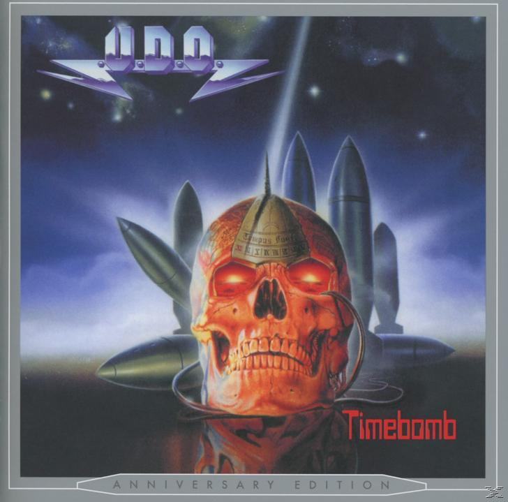 Albumcover mit Totenkopf, Raketen und Raumschiff. Text: U.D.O. Timebomb, Anniversary Edition.