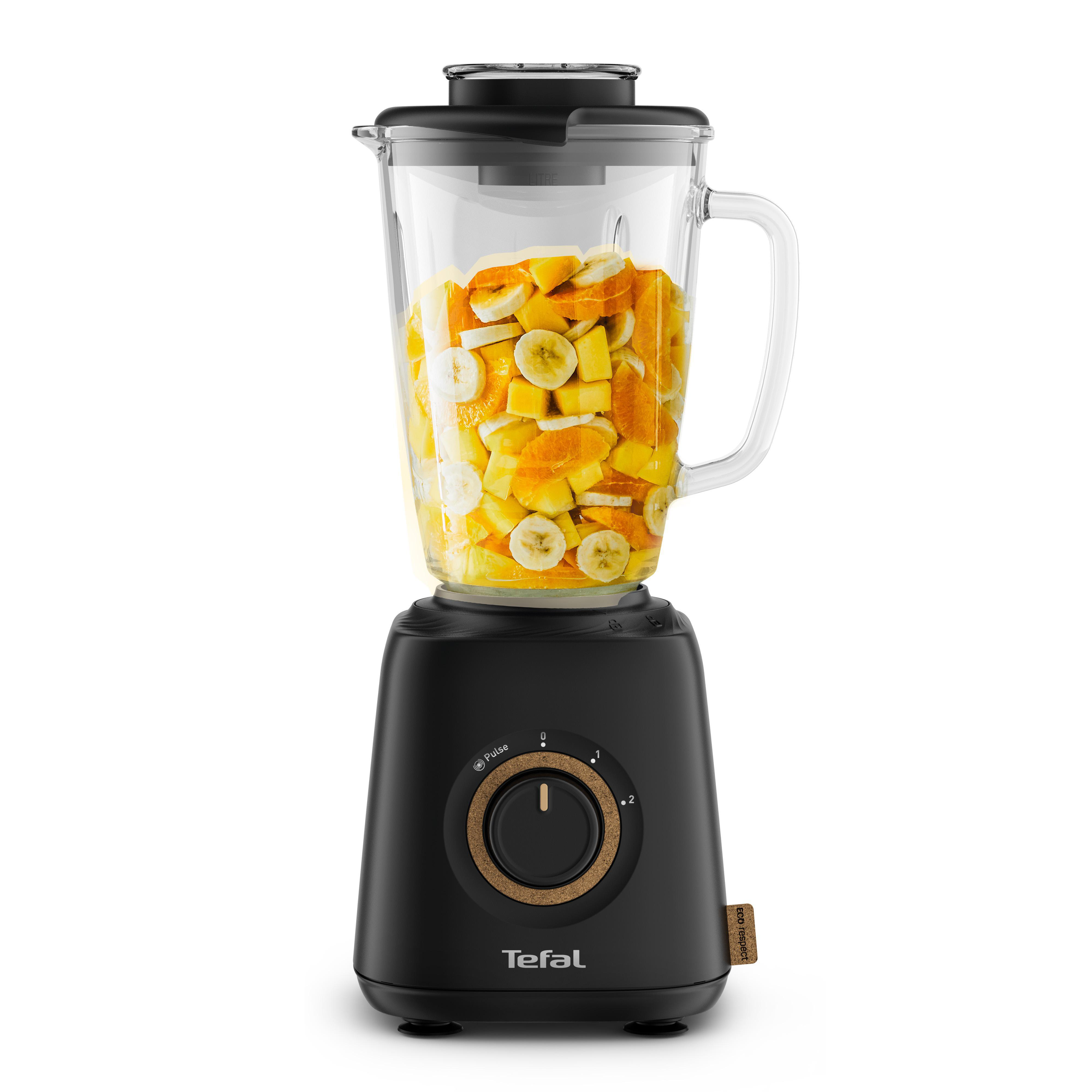 Ein schwarzer Mixer mit Früchten im Inneren. Er ist mit geschnittenen Bananen und Orangen gefüllt.