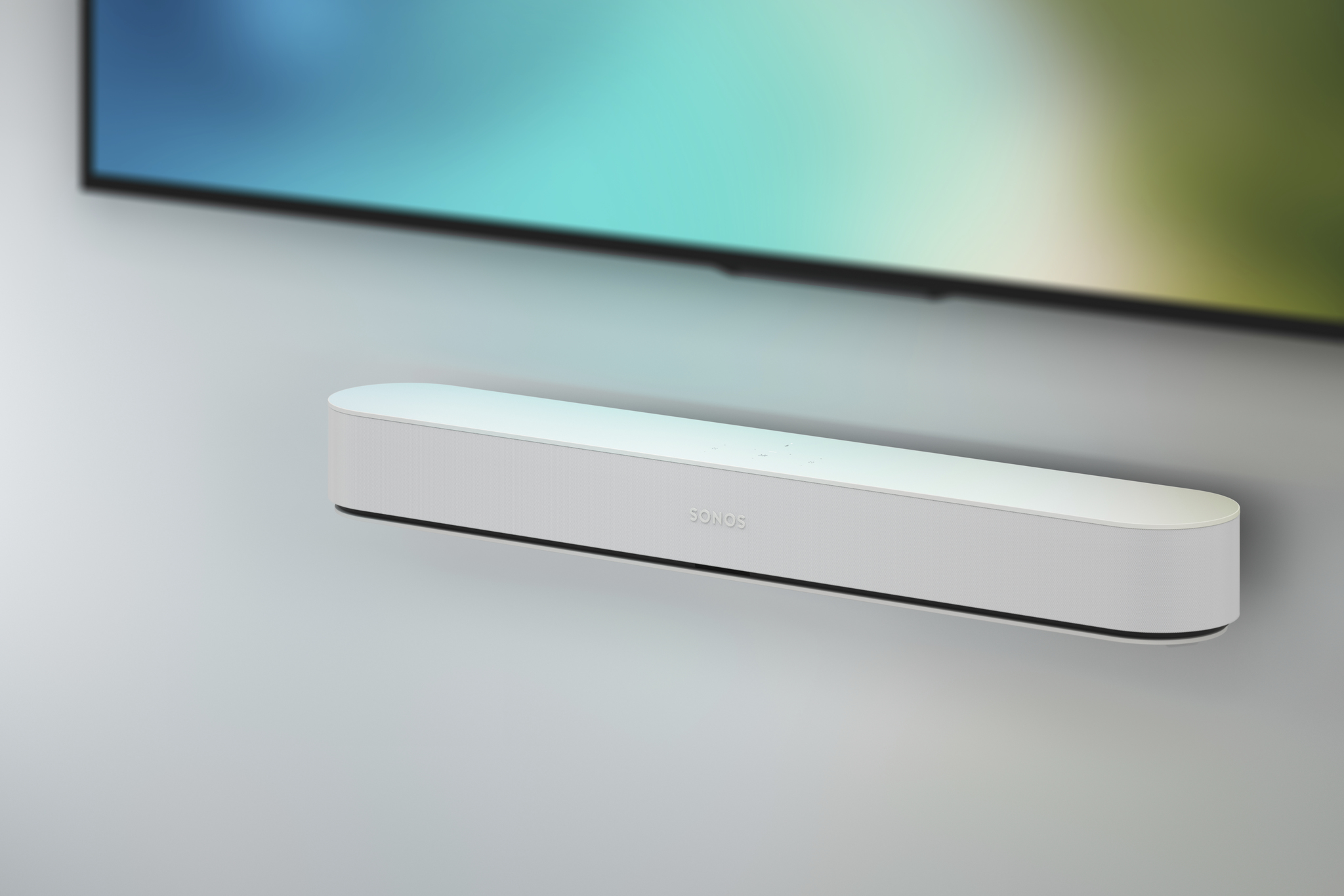 Una soundbar Sonos bianca montata a parete sotto un televisore.