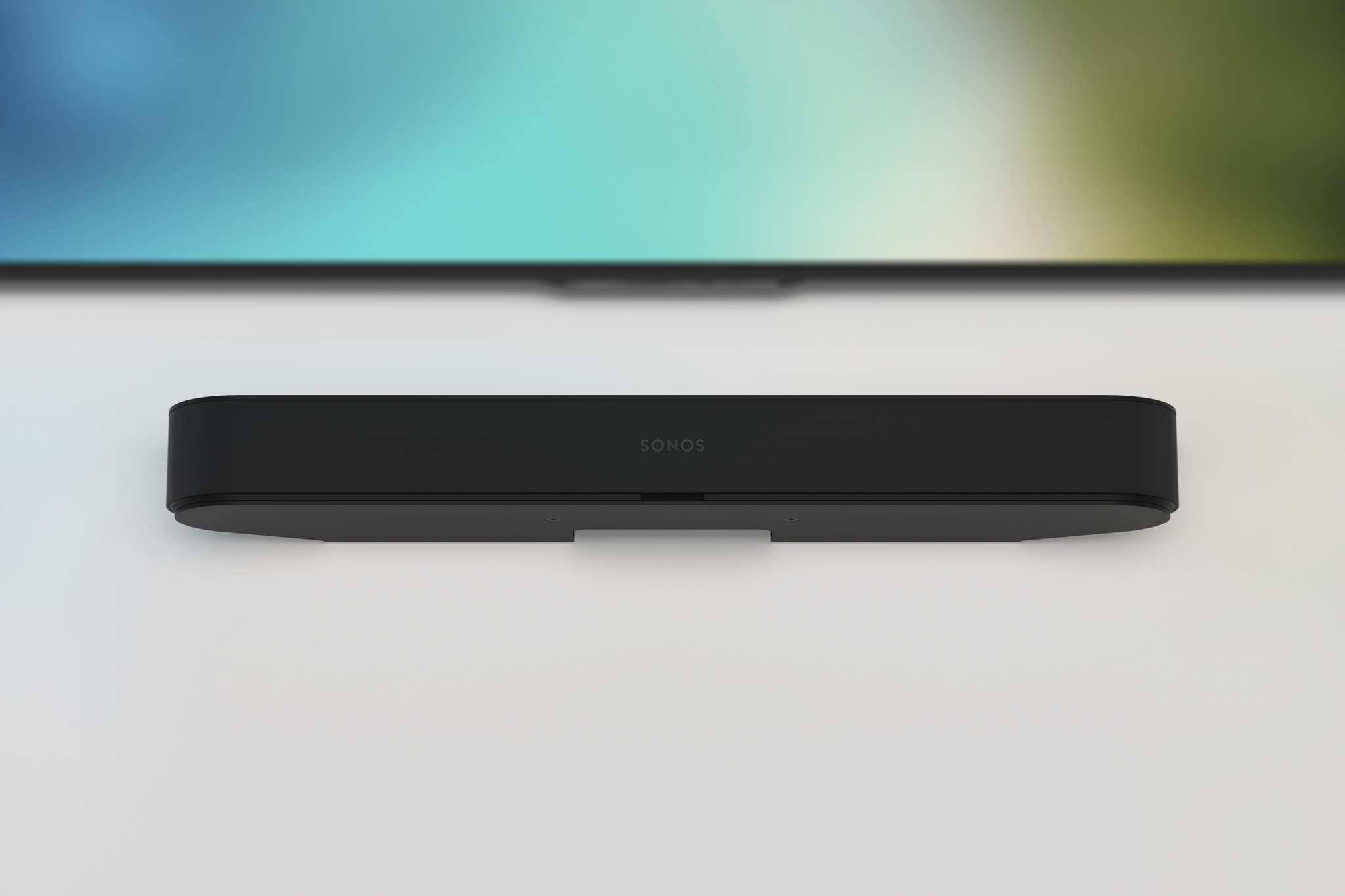 Una soundbar nera, montata a parete, sotto uno schermo.