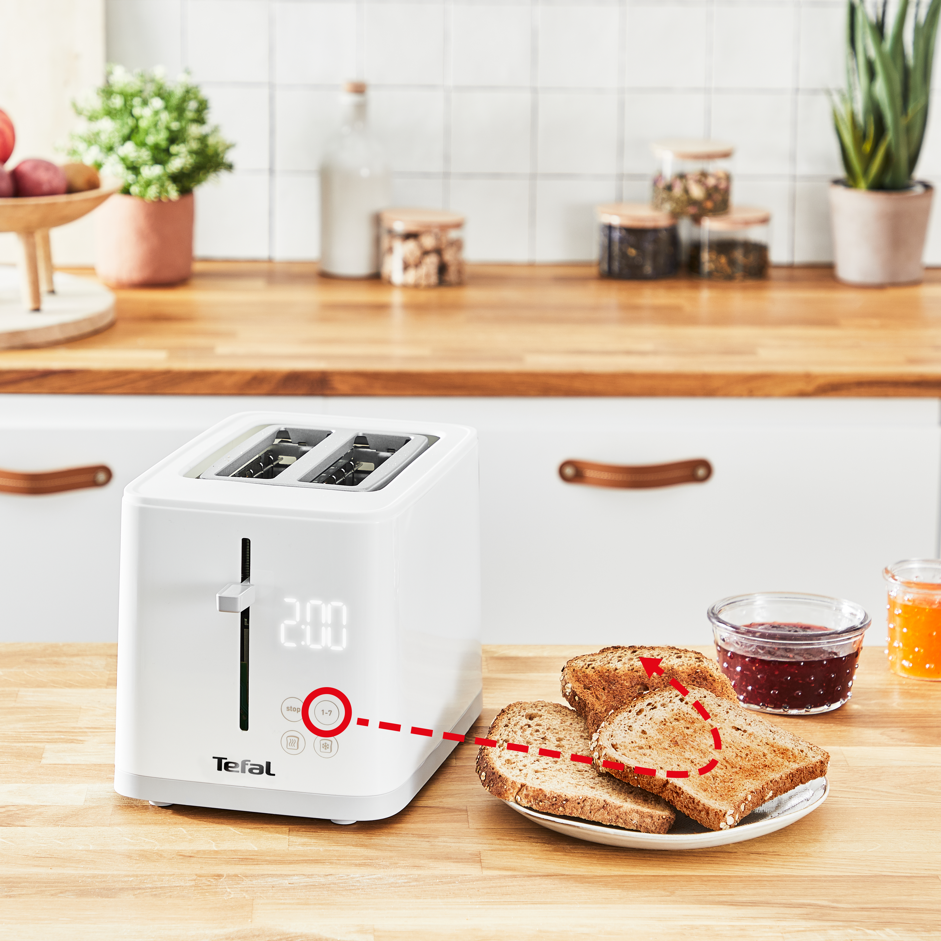 Weißer Toaster mit Toast und Marmelade auf einer Holztheke in der Küche.
