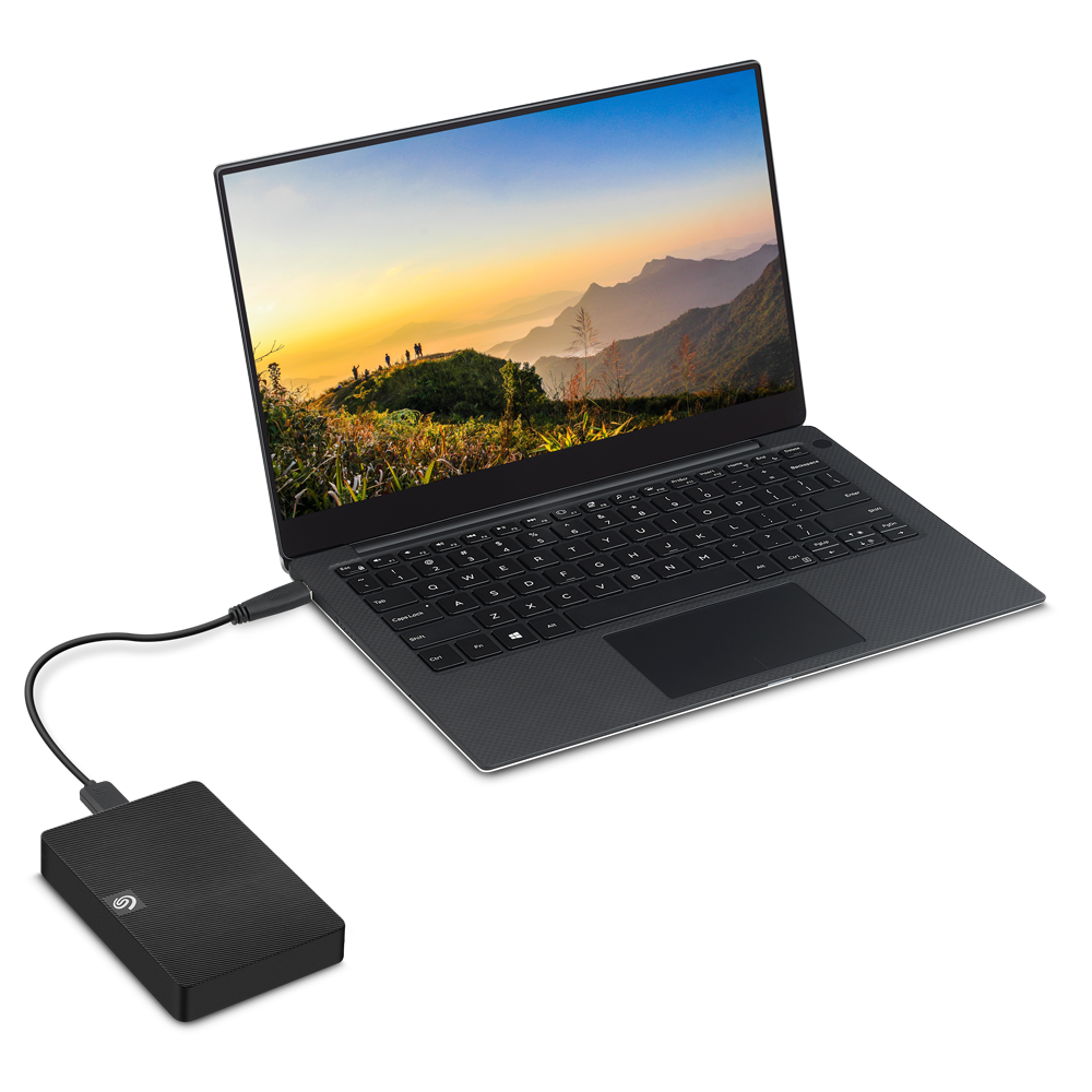 Laptop connected to a black hard drive. A scenic background is on the screen.