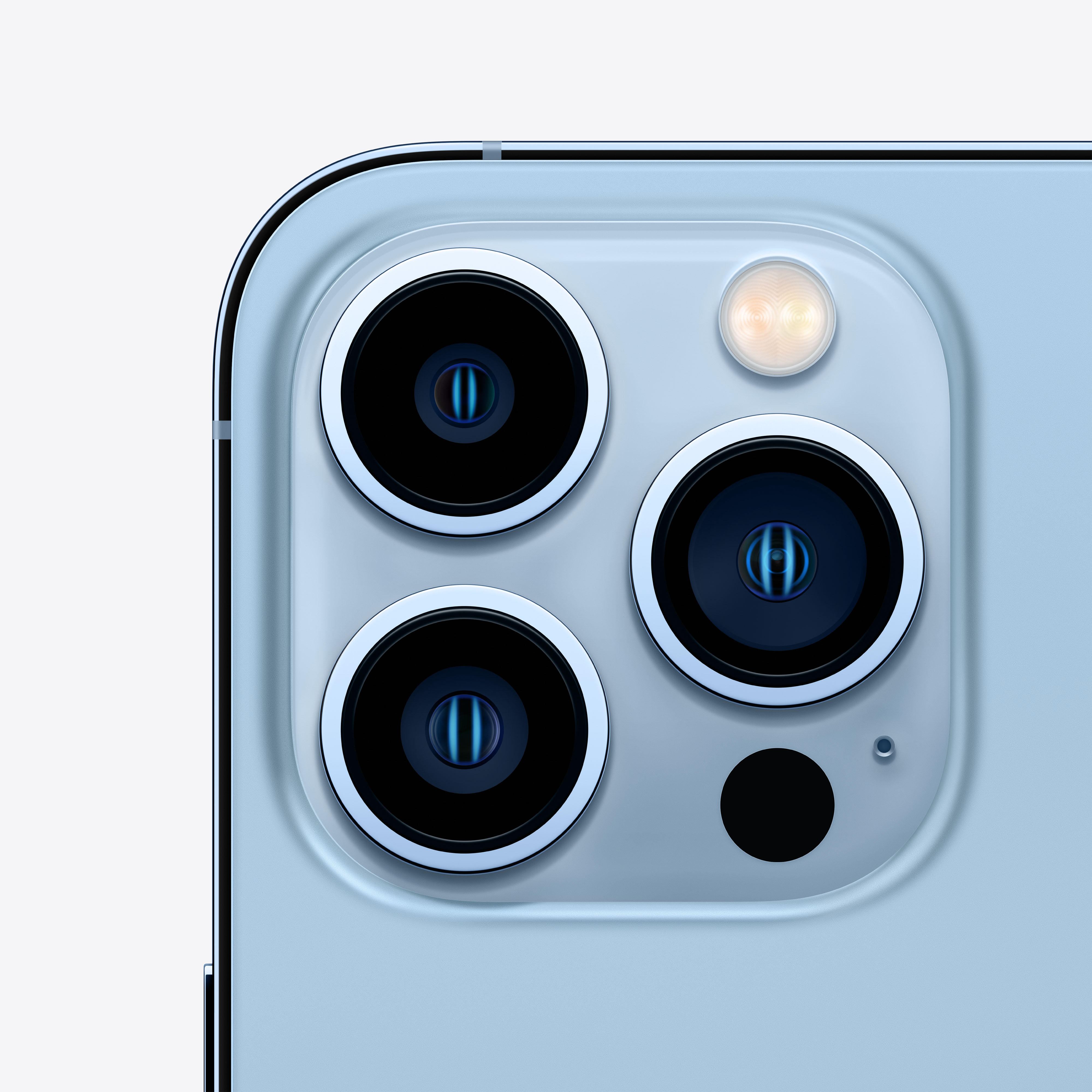 Primer plano de la parte trasera de un iPhone azul. Hay tres lentes de cámara y un flash.