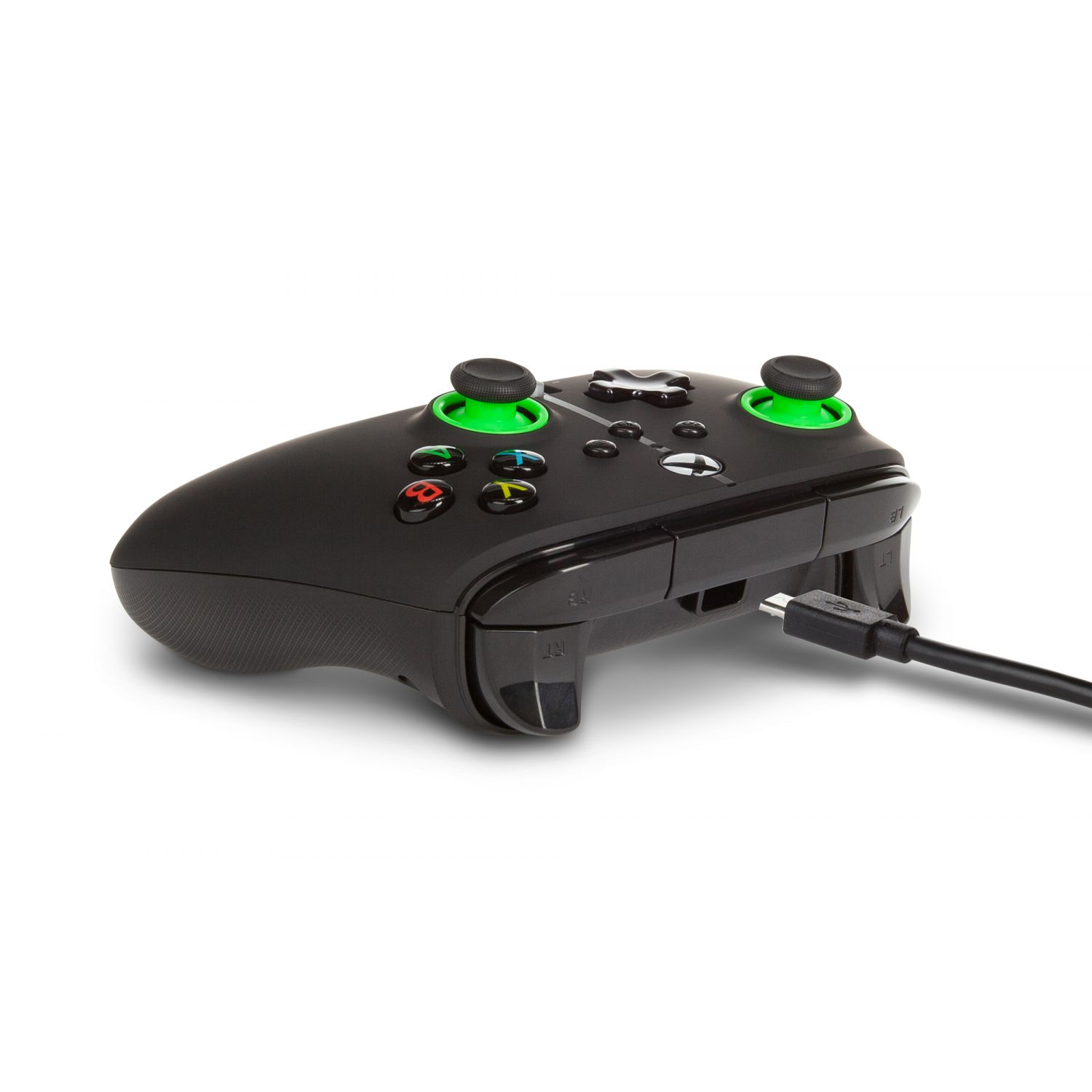 Controlador Xbox negro con detalles verdes, conectado por cable USB. Botones con símbolos de colores. Está sobre una superficie blanca.