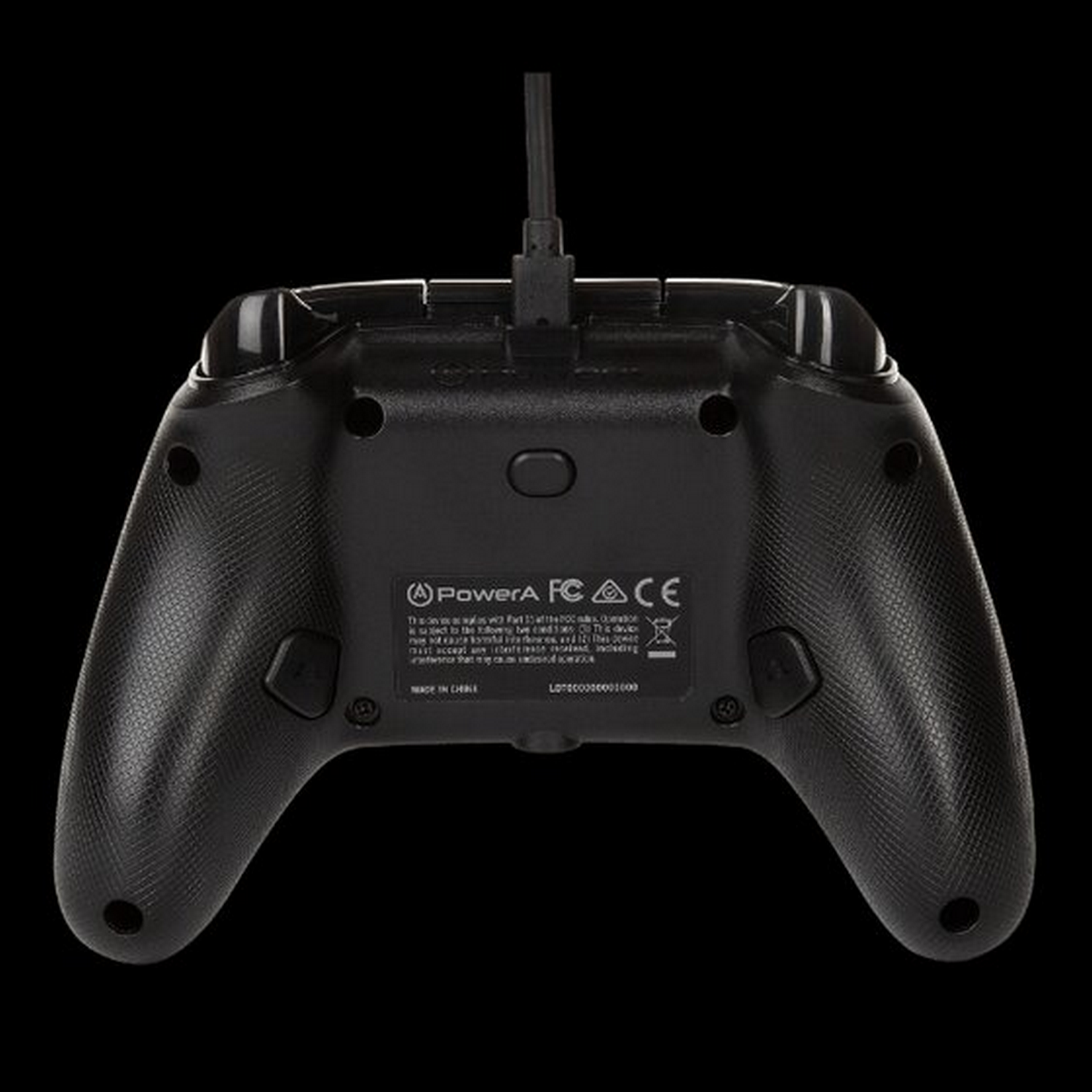 Mando de juego negro, vista trasera, con botones, un cable y texto. Fondo negro.