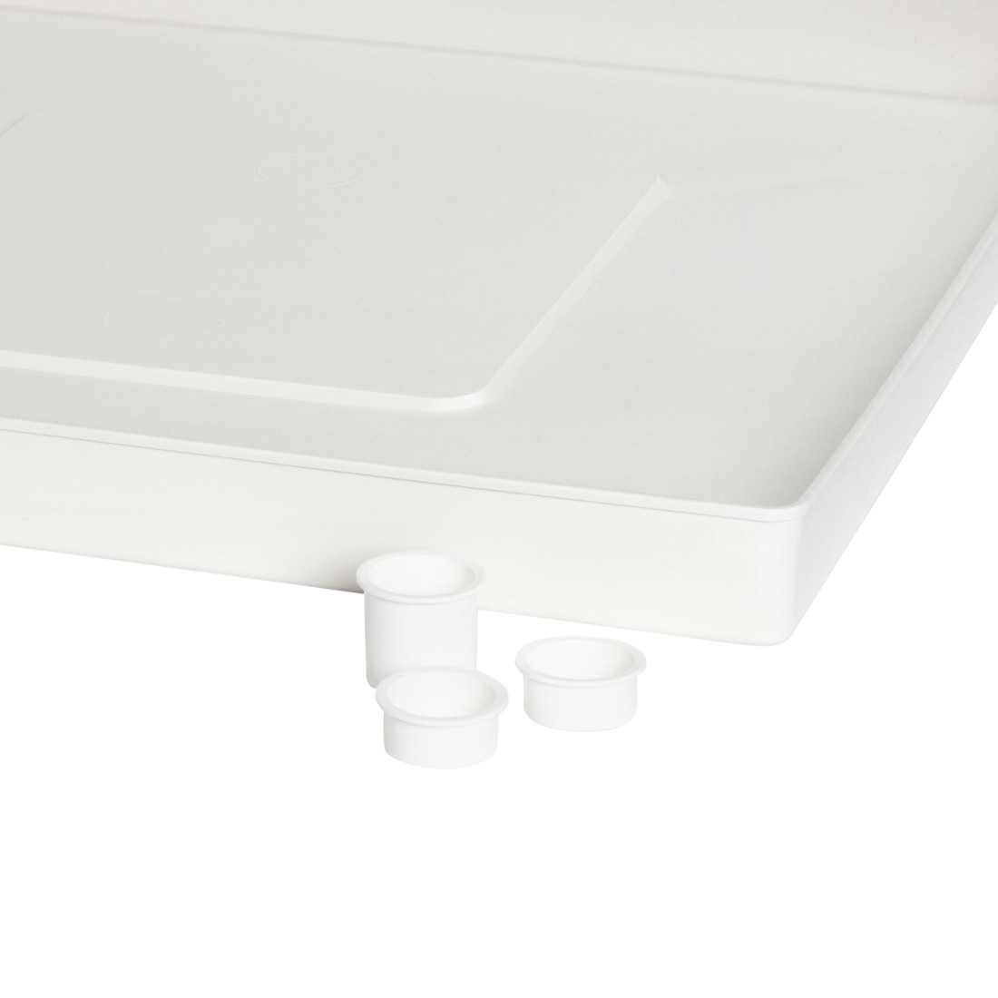 Un plateau en plastique blanc avec trois bouchons cylindriques blancs. Sur fond blanc.