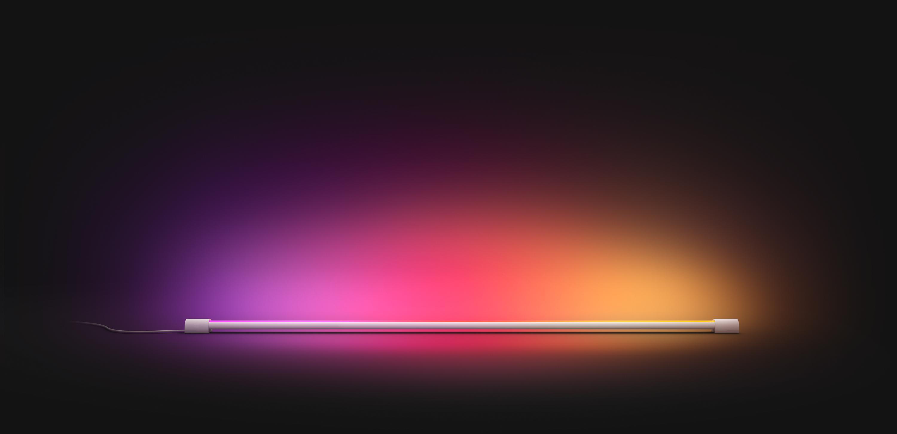 Ein farbenfroher Lichtbalken vor dunklem Hintergrund. Das Licht ist pink, orange und lila.