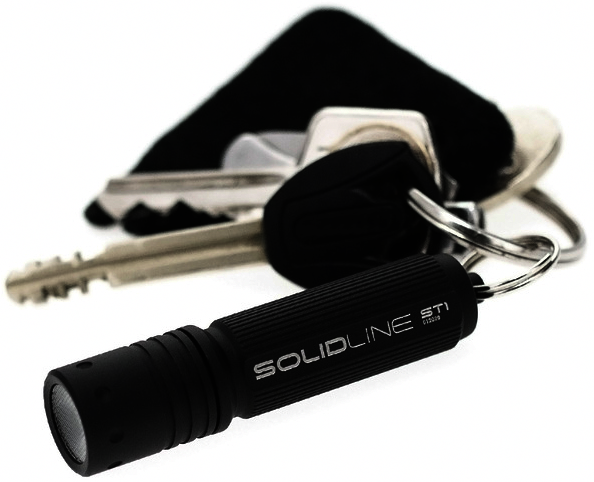 Schwarze Taschenlampe mit Schlüsseln im Hintergrund. Auf der Taschenlampe steht das Wort SOLIDLINE.