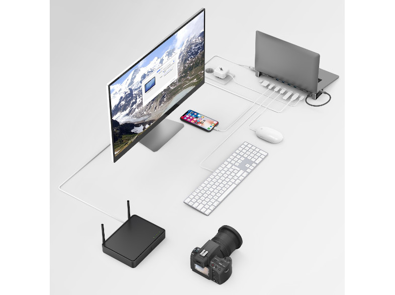 Egy asztali beállítás monitorral, laptoppal, telefonnal, kamerával és routerrel.