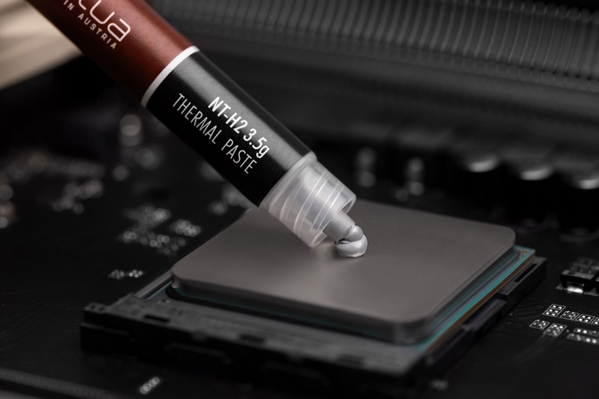 Noctua Wärmeleitpaste wird auf eine CPU auf einem Motherboard aufgetragen, Nahaufnahme.