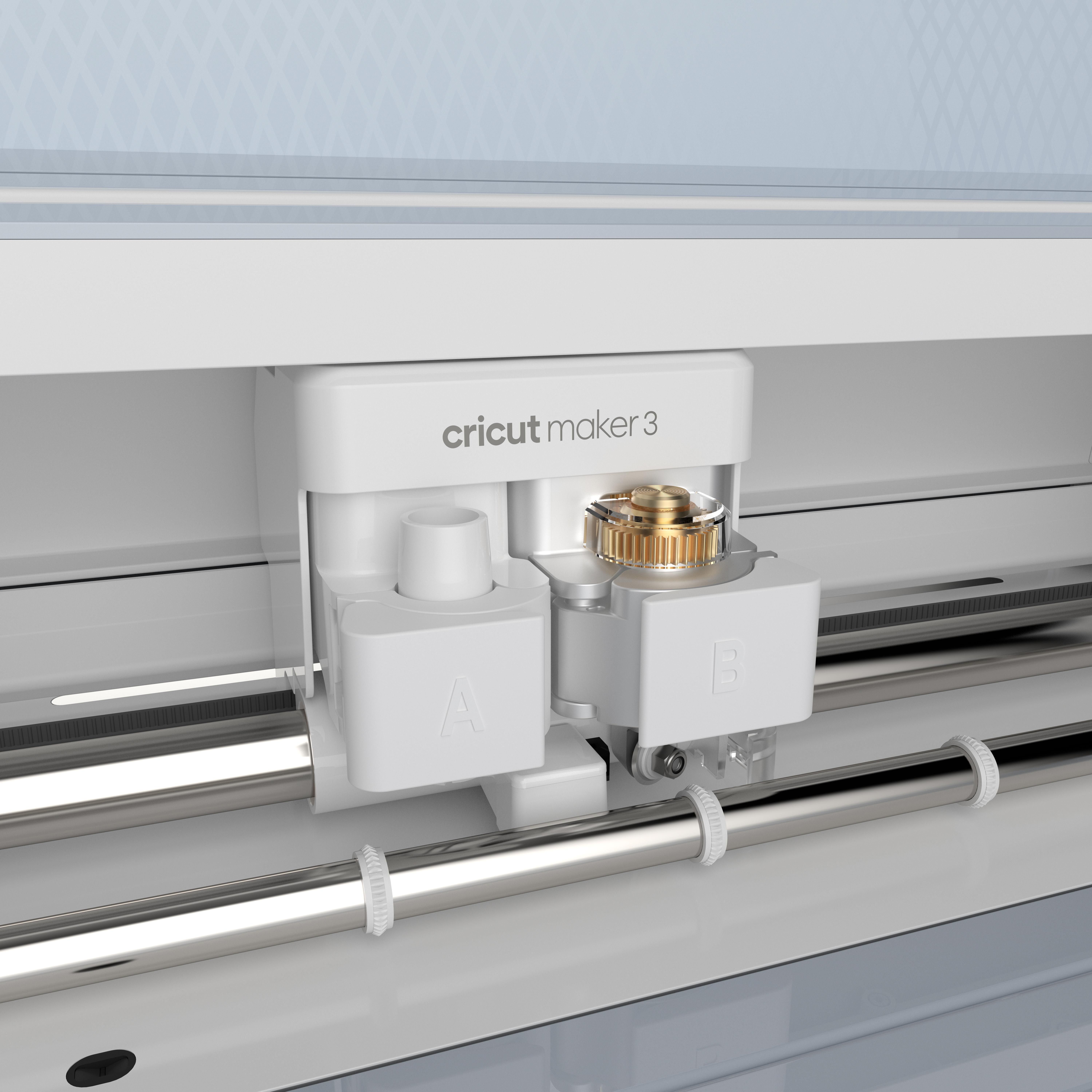 Eine Cricut Maker 3 Maschine mit Schneidwerkzeugen und zwei weißen Kästen mit A und B beschriftet.