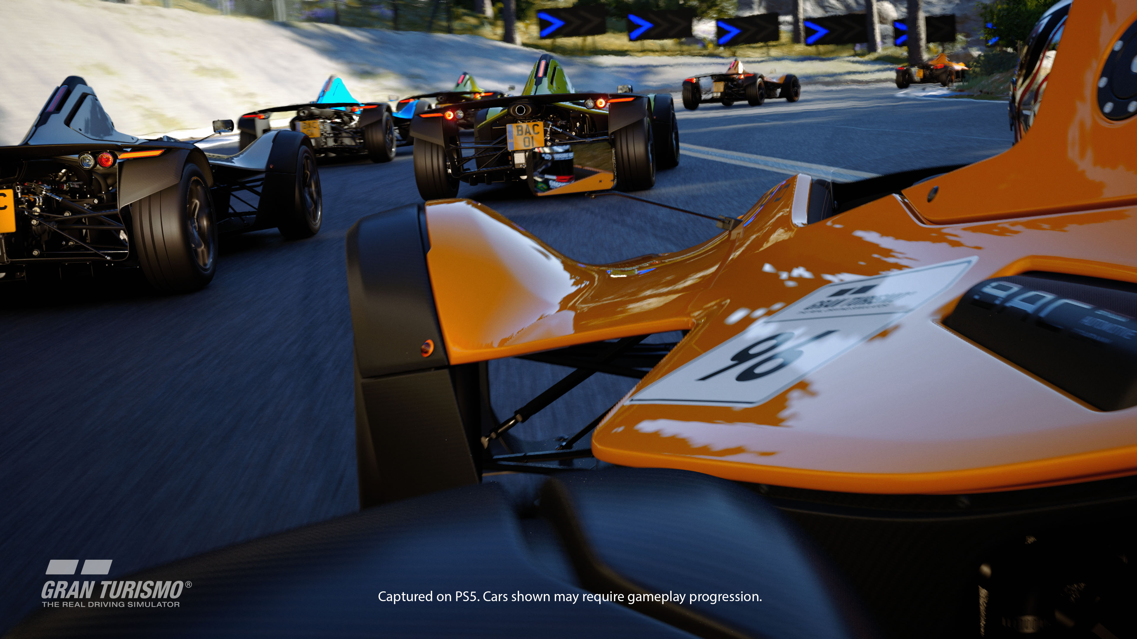Scène de course automobile, plusieurs voitures sur une piste. Voiture orange vif au premier plan.