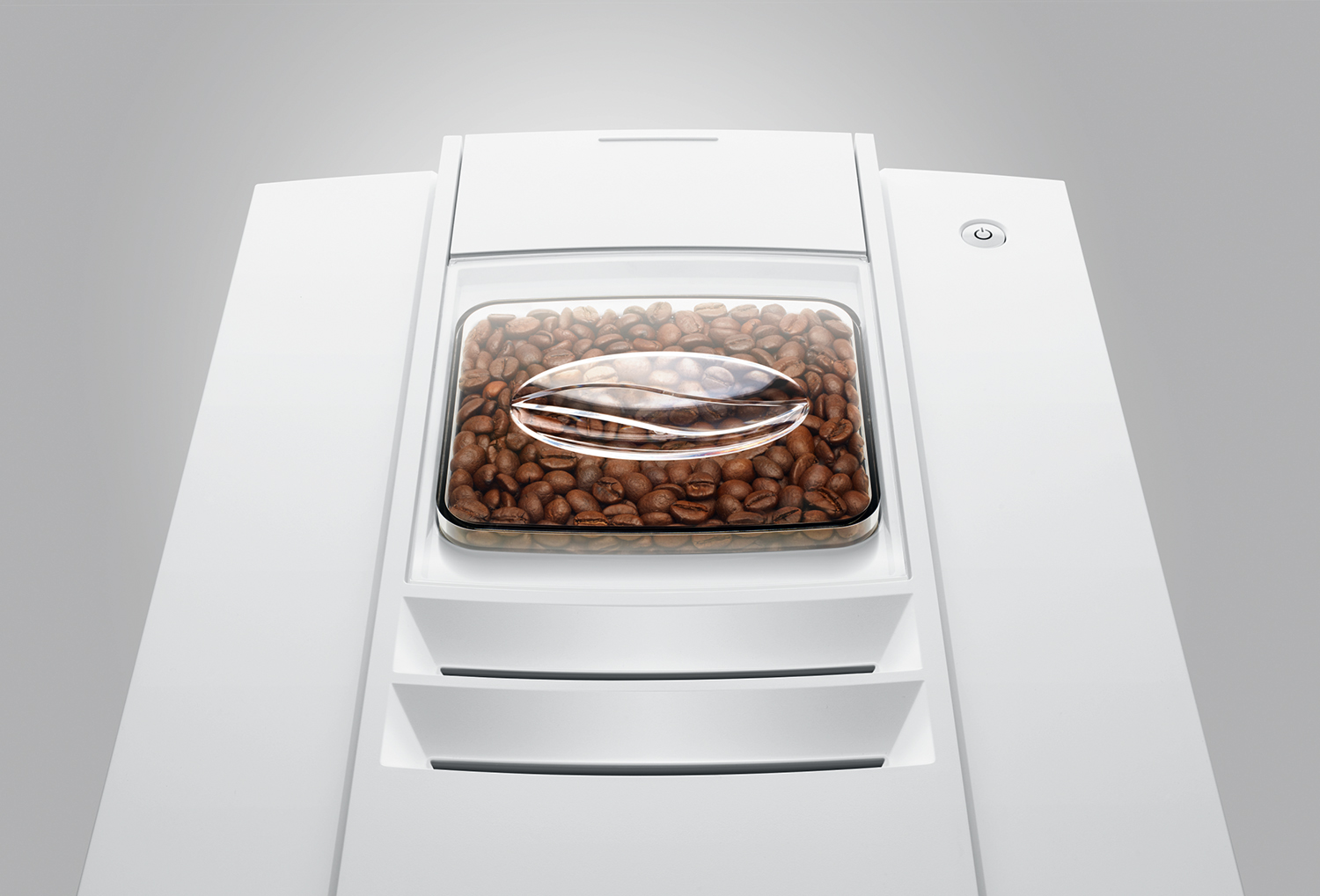 A coffee machine with coffee beans inside a transparent container. White machine.