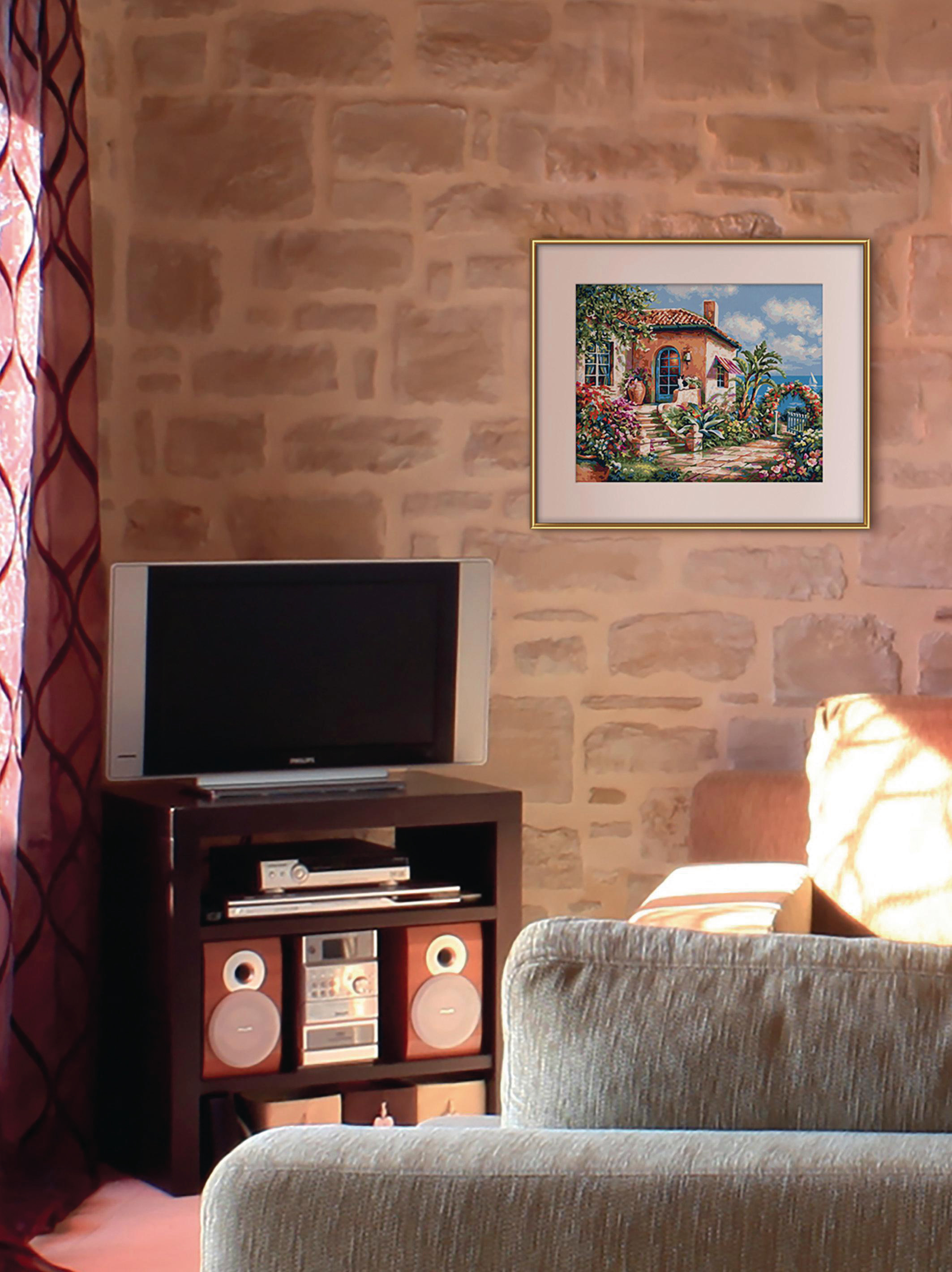 Ein Wohnzimmer mit Steinwand, Fernseher, Stereoanlage, Sofa und einem Gemälde eines Hauses.