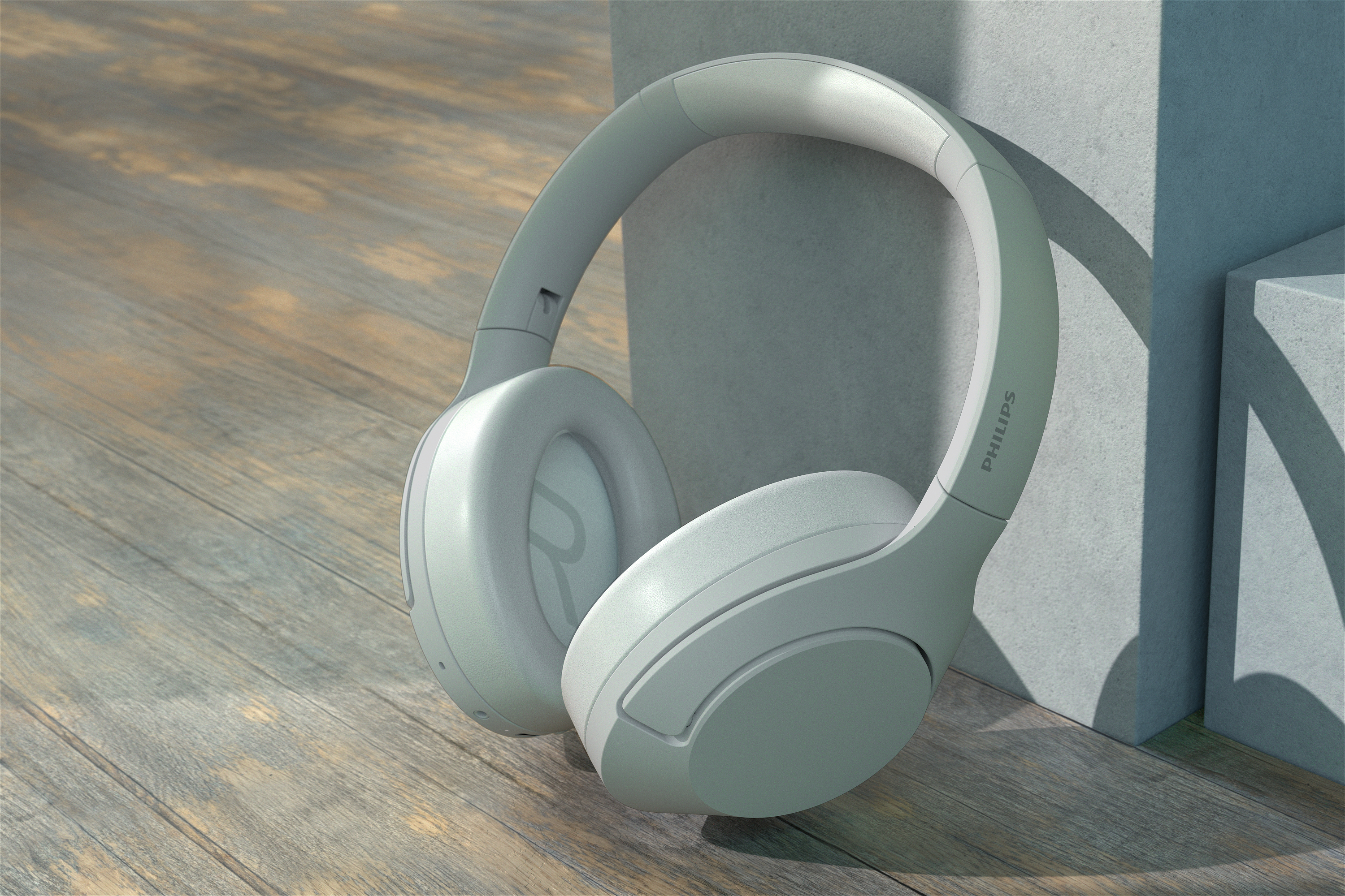 Weiße Kopfhörer auf Holzoberfläche, neben grauer Wand.