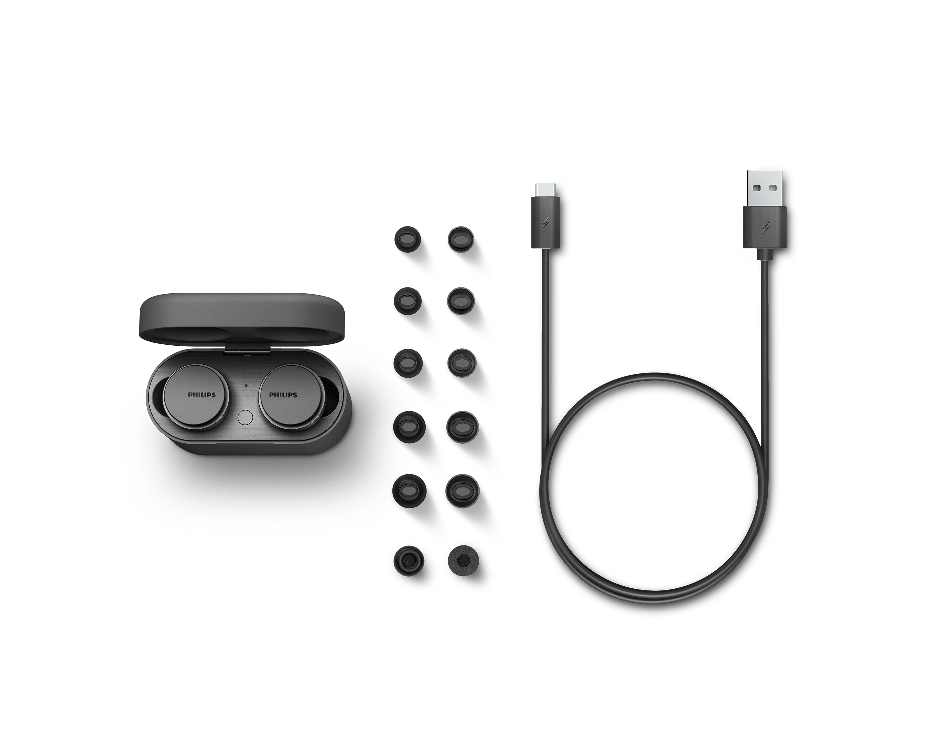 Philips kabellose Ohrhörer, Ladecase, Ladekabel und Ohrstöpsel. Weißer Hintergrund.