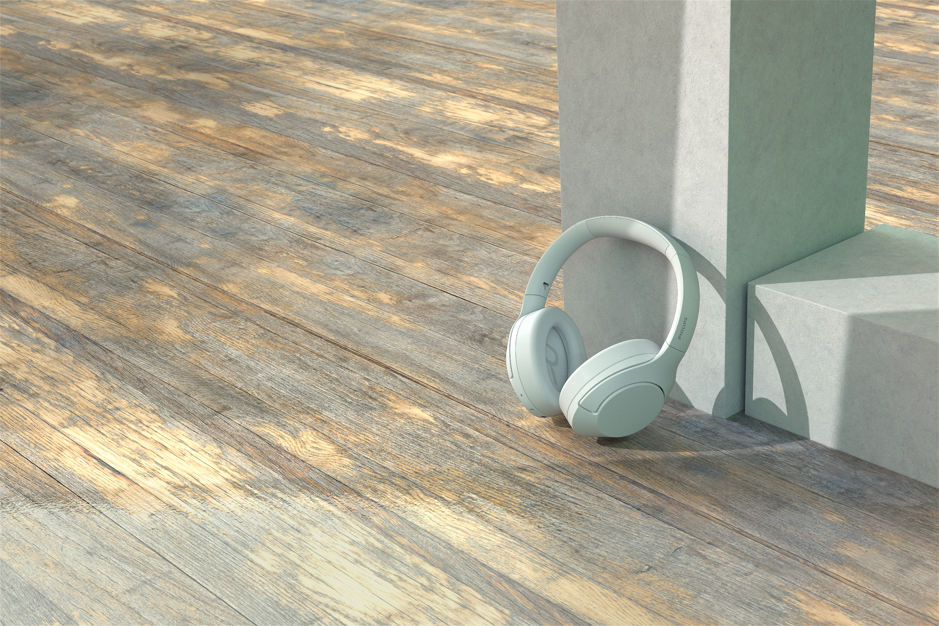 Hellblaue Kopfhörer auf einer Holzoberfläche, in der Nähe von grauen Blöcken.