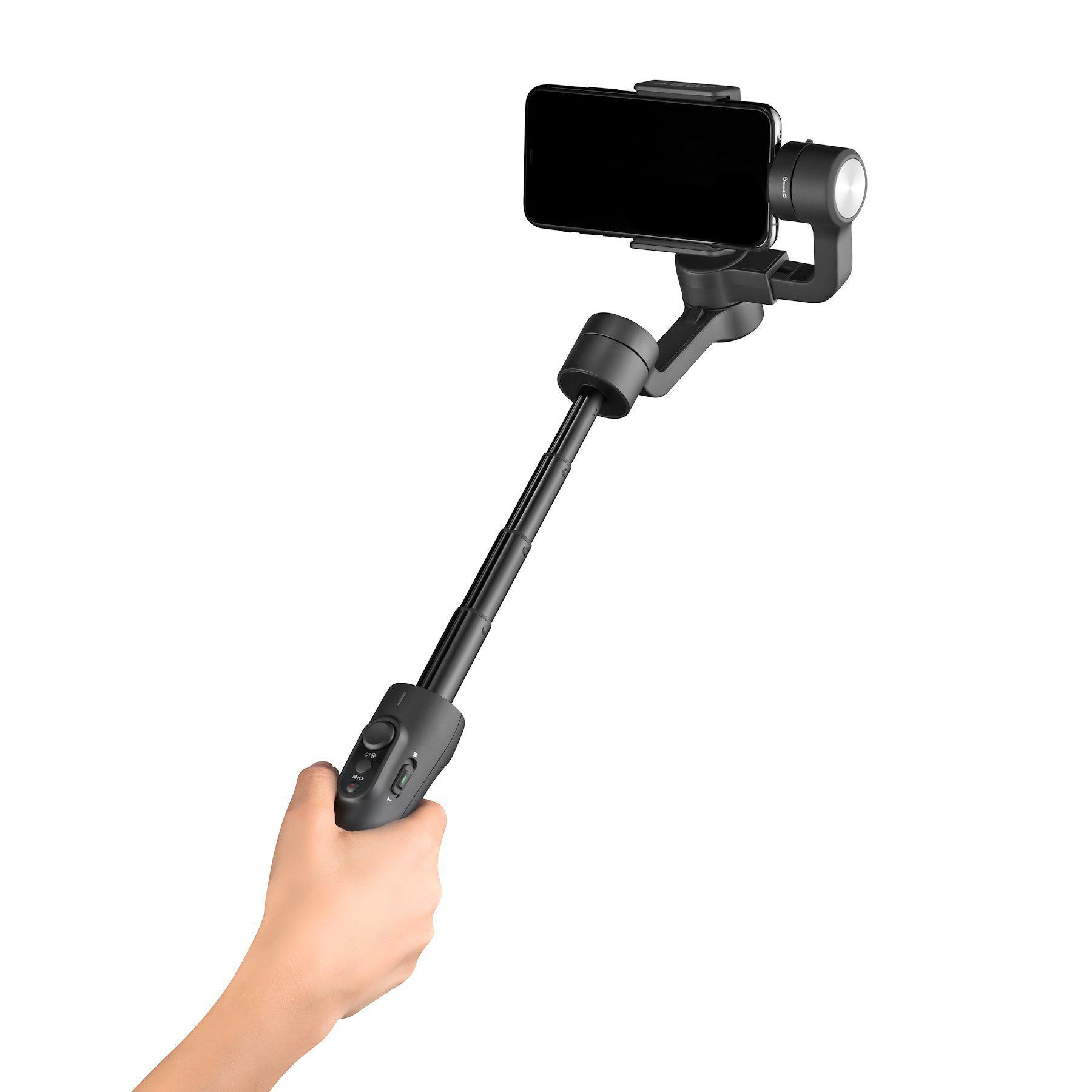 Hand hält schwarzen Selfie-Stick mit Telefon. Steuerung am Stick. Weißer Hintergrund.