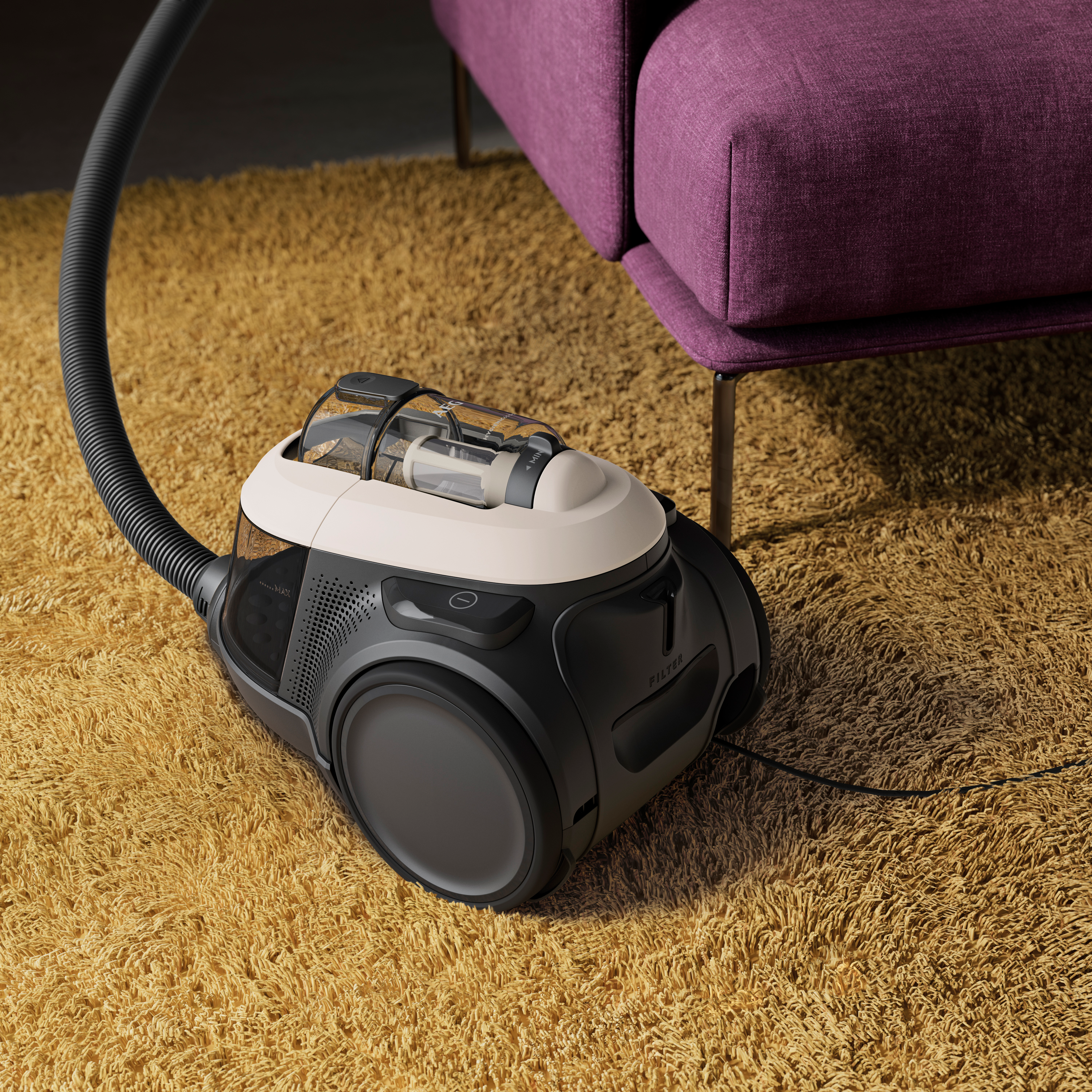 Ein schwarz-beige Staubsauger auf einem gelben Teppich, in der Nähe eines lila Sofas.
