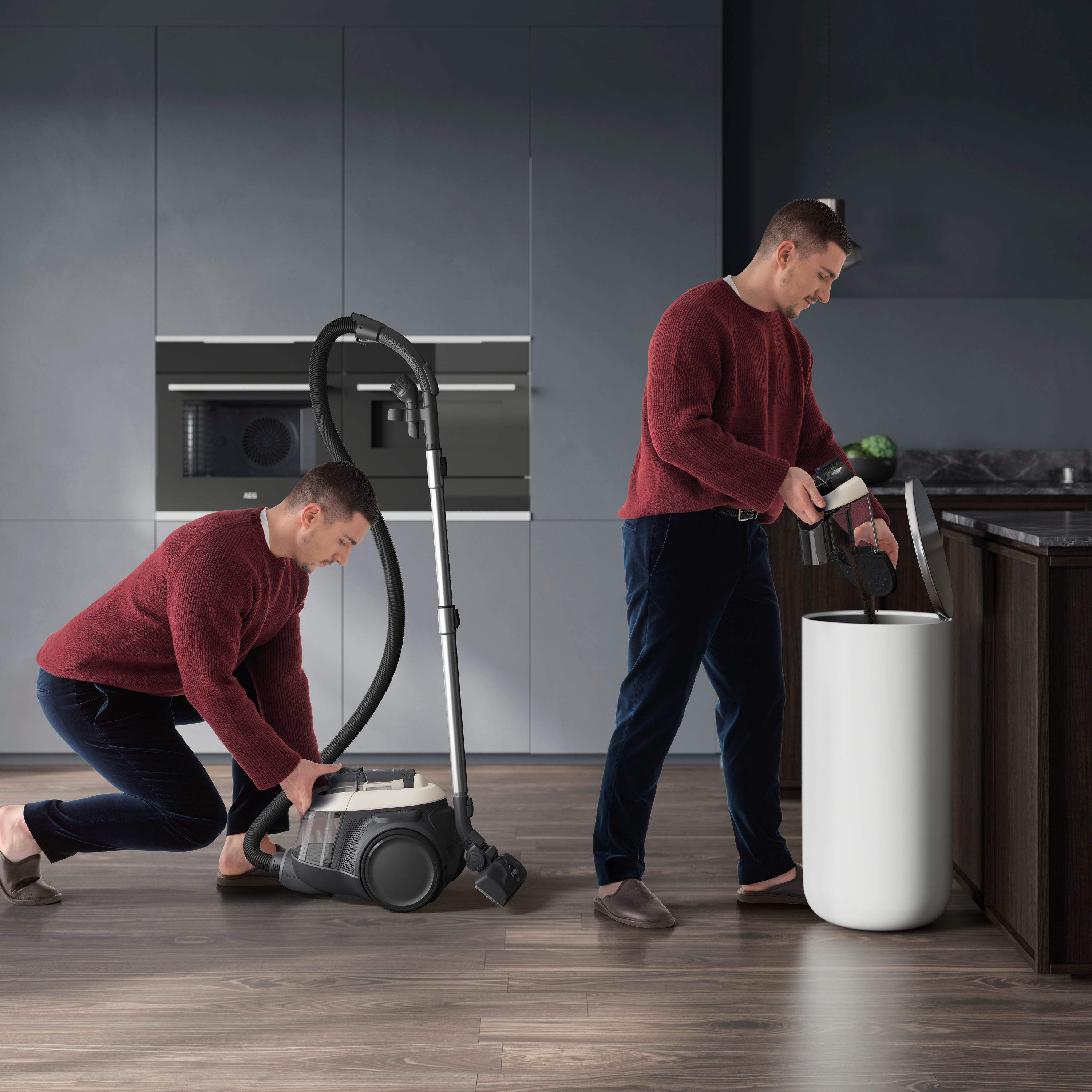 Mann im roten Pullover leert Staubsauger in einen weißen Mülleimer in der Küche.
