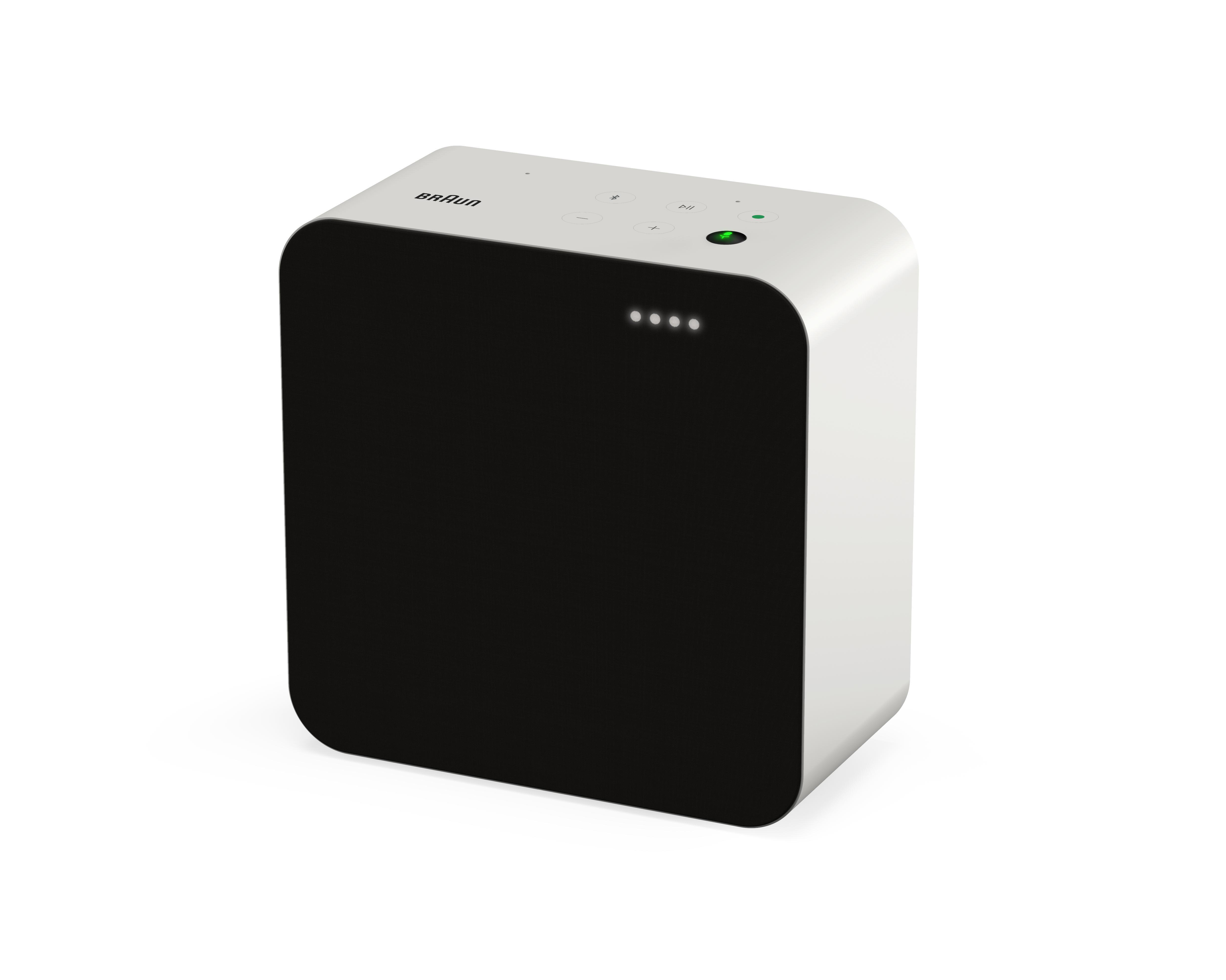Ein weiß-schwarzer Braun-Lautsprecher mit schlichtem Design, vier Punkten und einem grünen Licht.