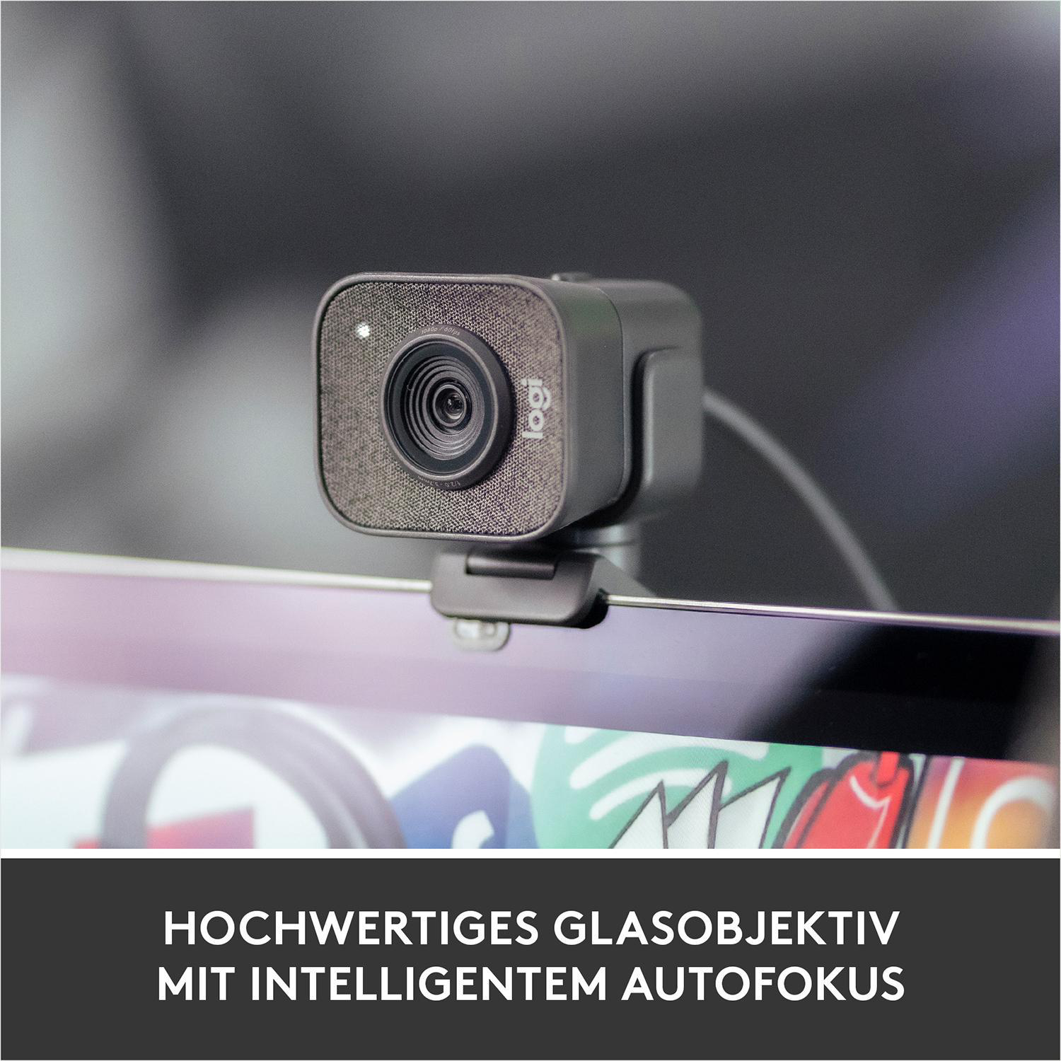 Eine Logitech Webcam auf einem Monitor, mit Text: 'HOCHWERTIGES GLASOBJEKTIV MIT INTELLIGENTEM AUTOFOKUS'.