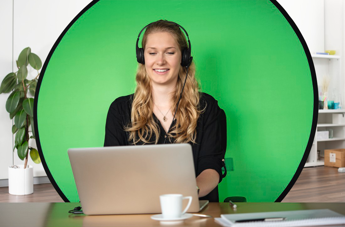 Une femme avec un casque utilise un ordinateur portable. Écran vert en arrière-plan.