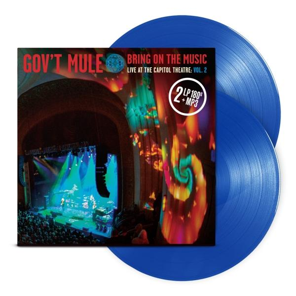 Albumcover mit Bandnamen, Live-Performance-Bild und zwei blauen Schallplatten.