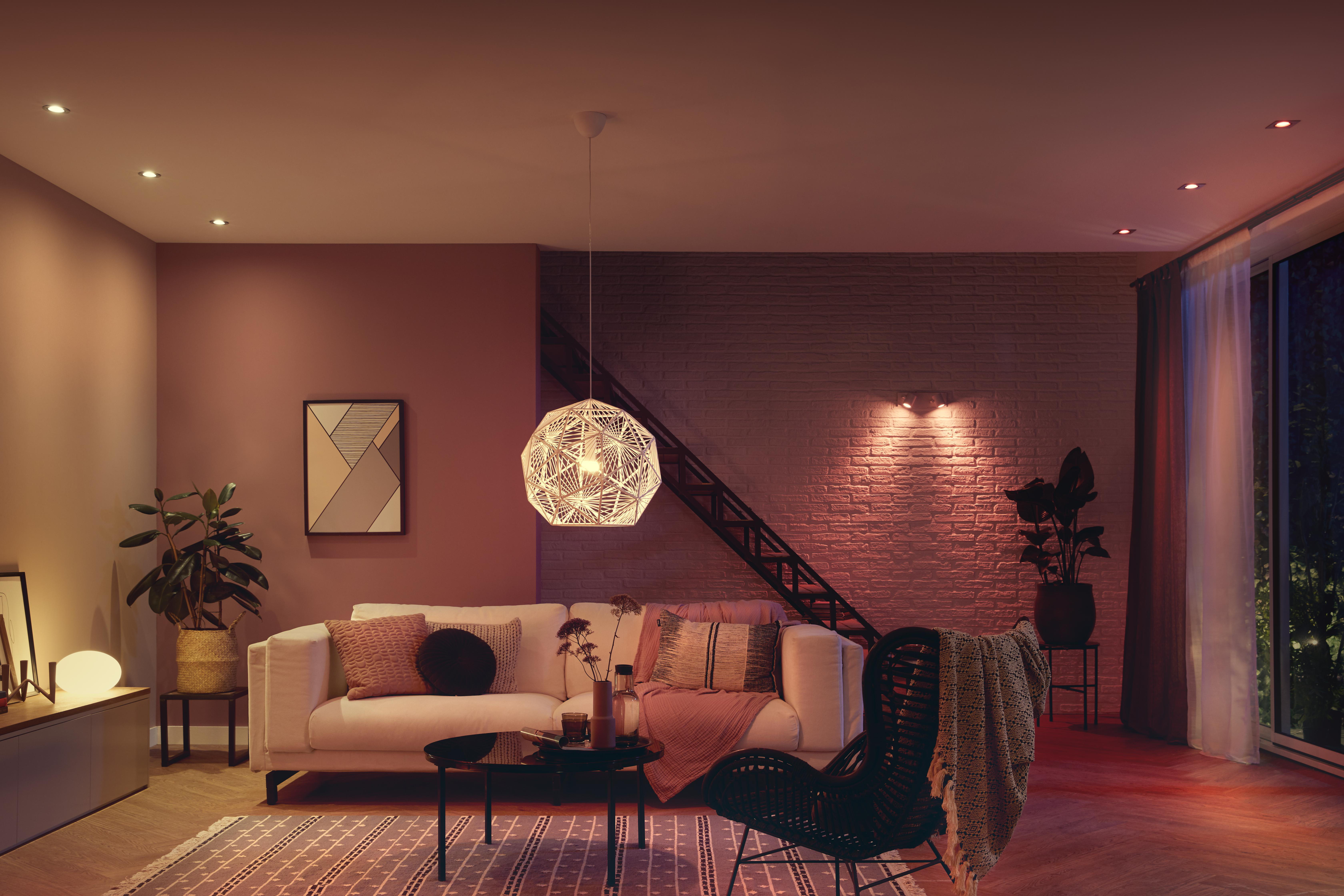 Wohnzimmer mit modernen Möbeln, Lampen und roter Beleuchtung.