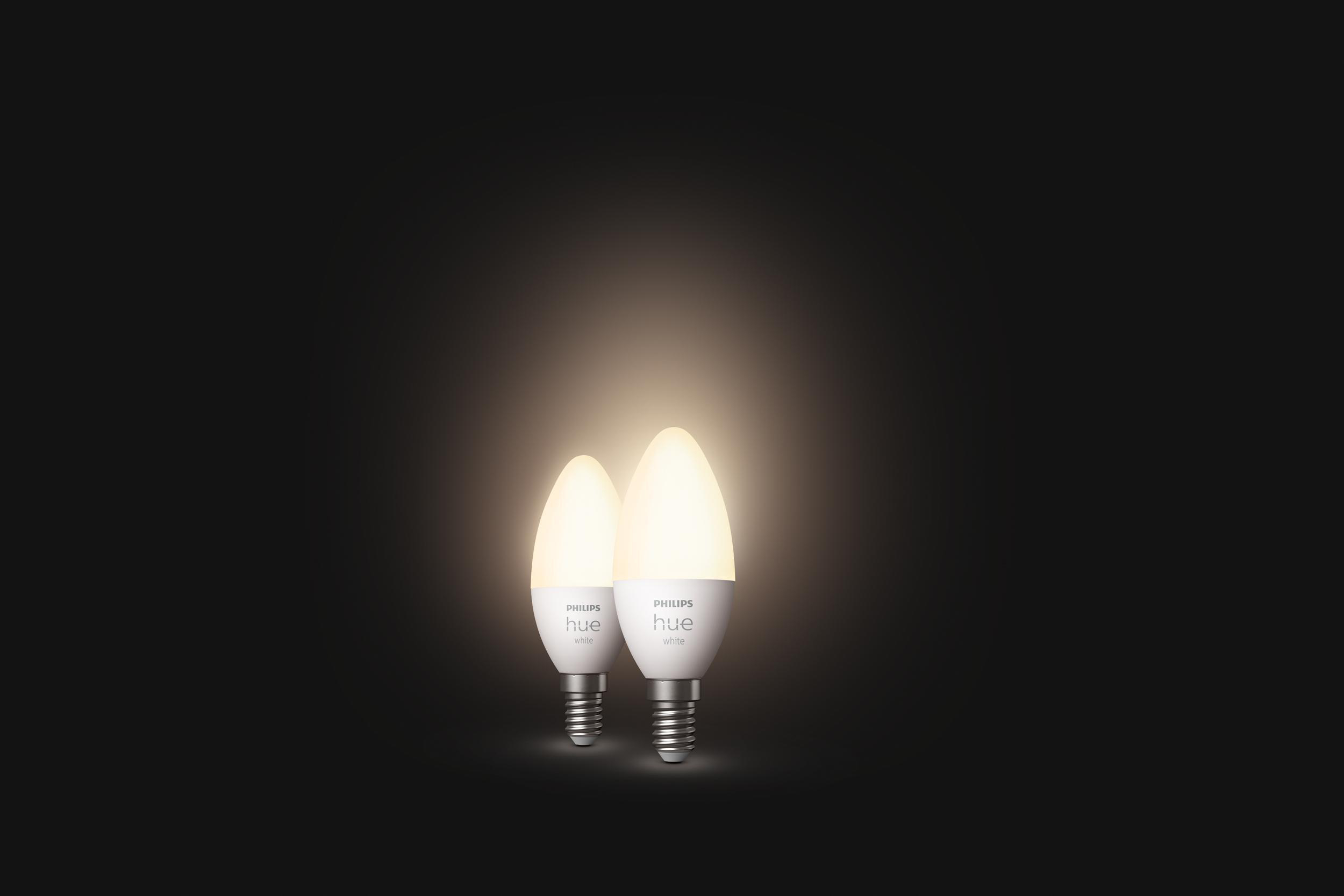Zwei weiße LED-Kerzenlampen mit dem Philips Hue-Logo auf schwarzem Hintergrund.