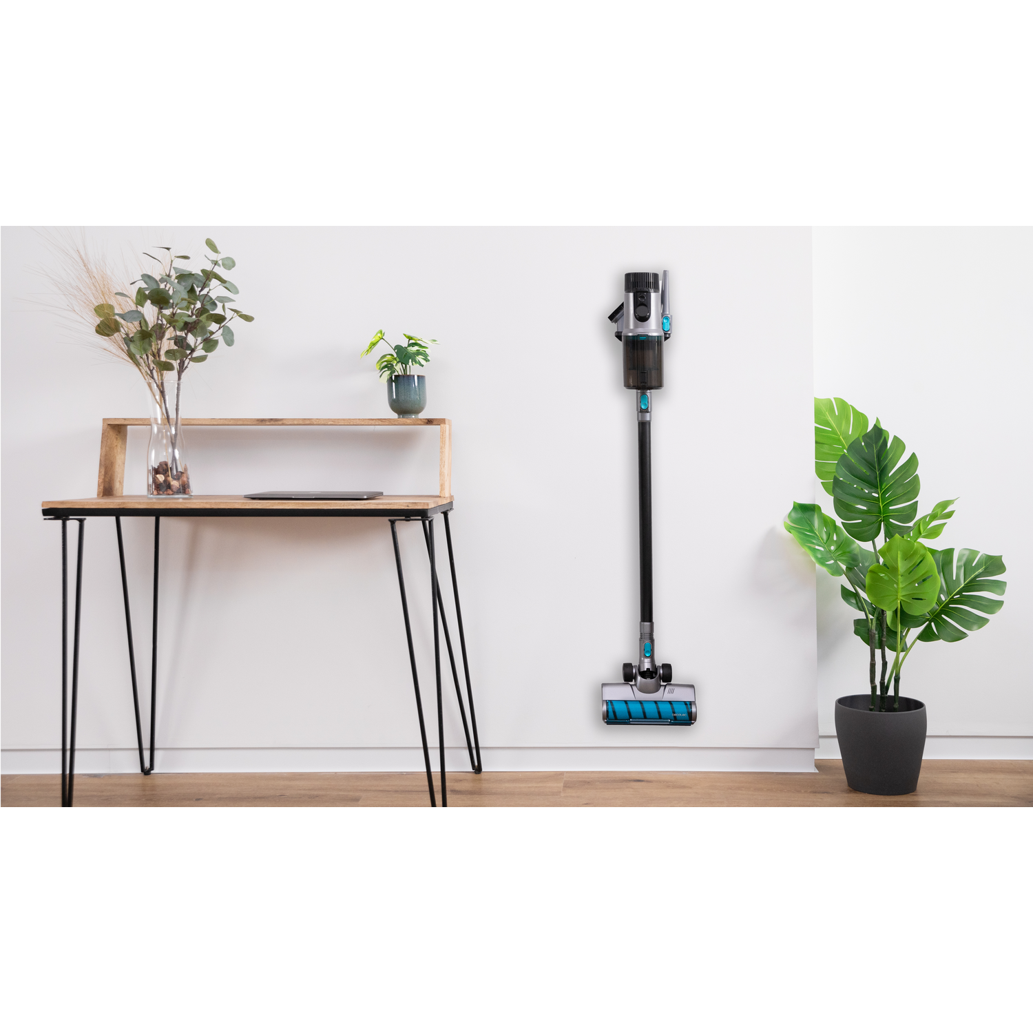 Aspiradora montada en la pared cerca de un escritorio de madera y una planta.