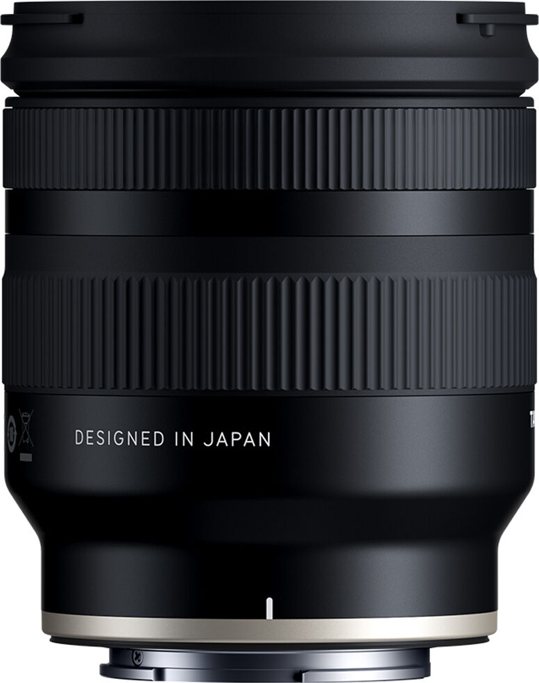 Objectif de caméra noir avec bagues de préhension côtelées et texte 'DESIGNED IN JAPAN'.