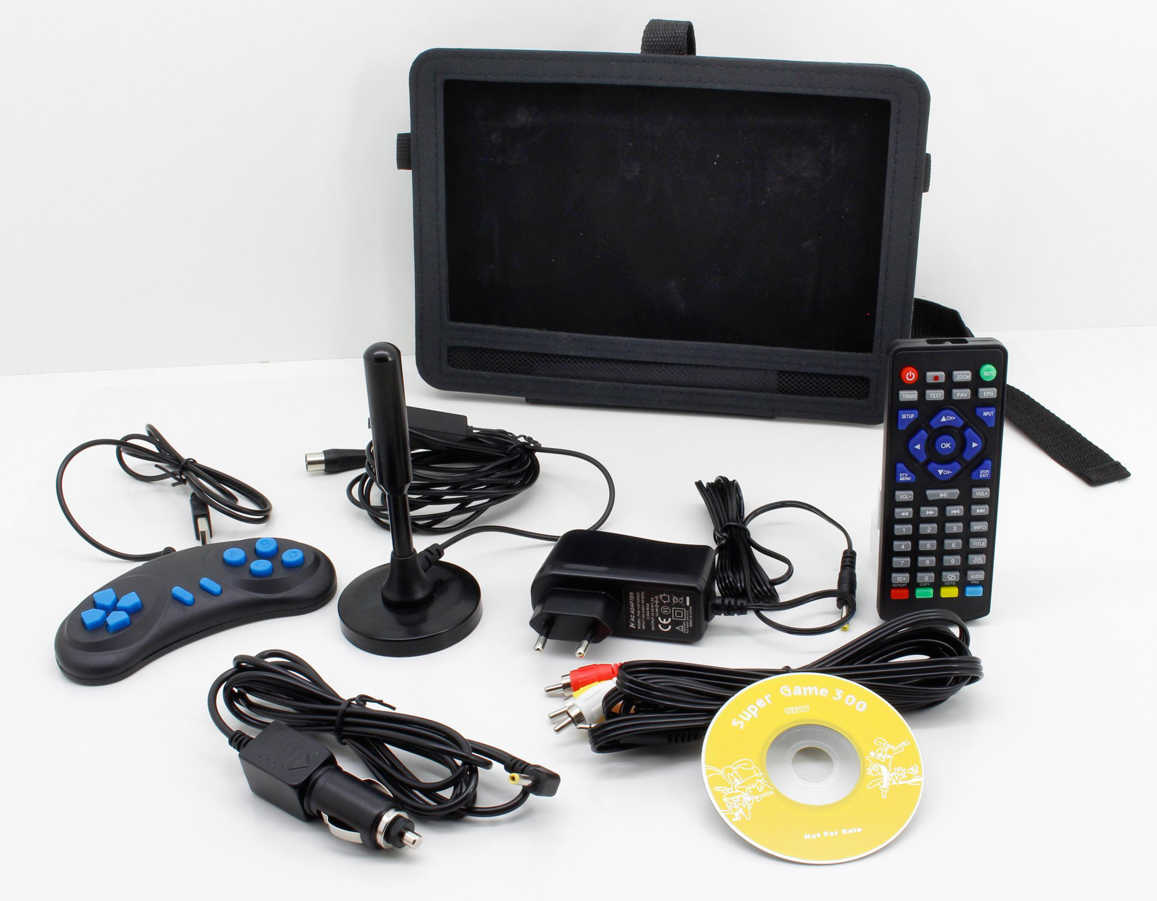Eine tragbare Spielkonsole und Zubehör: Controller, Netzteil, CD und Kabel auf einer weißen Oberfläche.