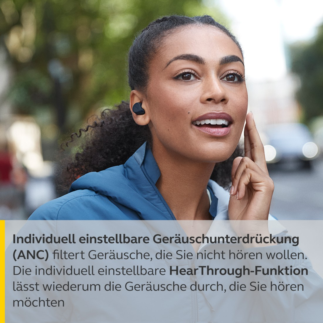 Eine Frau mit Ohrhörern deutet auf ihr Ohr. Text über Geräuschunterdrückung ist sichtbar.