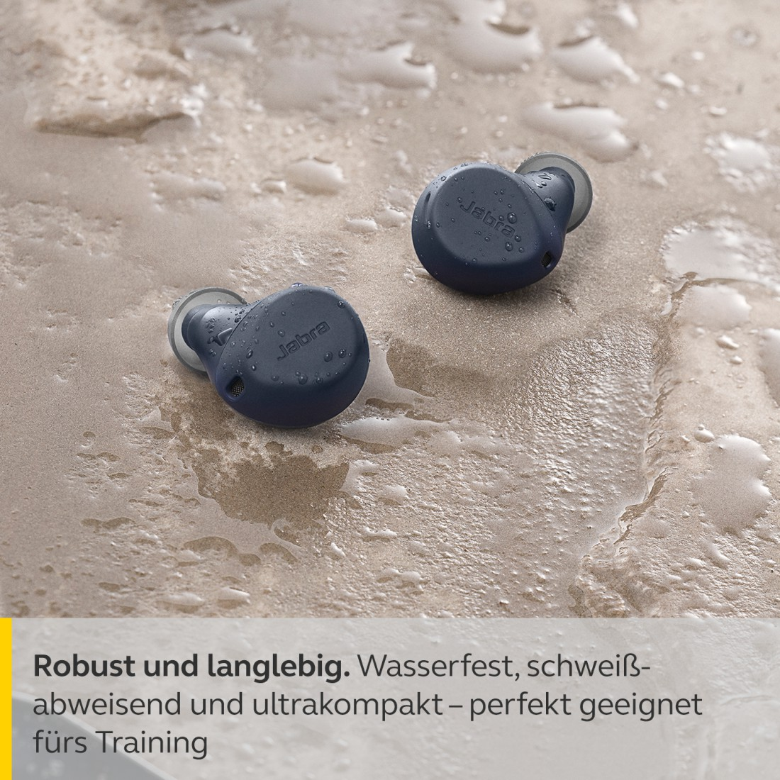 Zwei marineblaue Ohrhörer auf nasser Oberfläche.