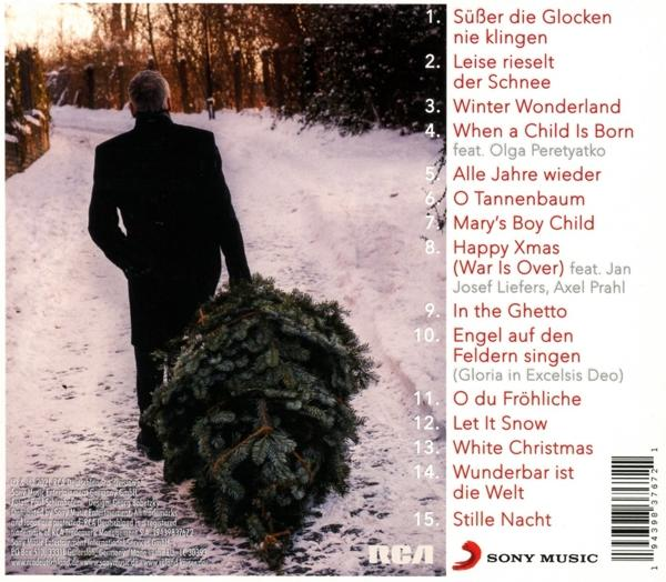 CD-Cover mit Titelliste und Person, die einen Weihnachtsbaum im Schnee trägt.