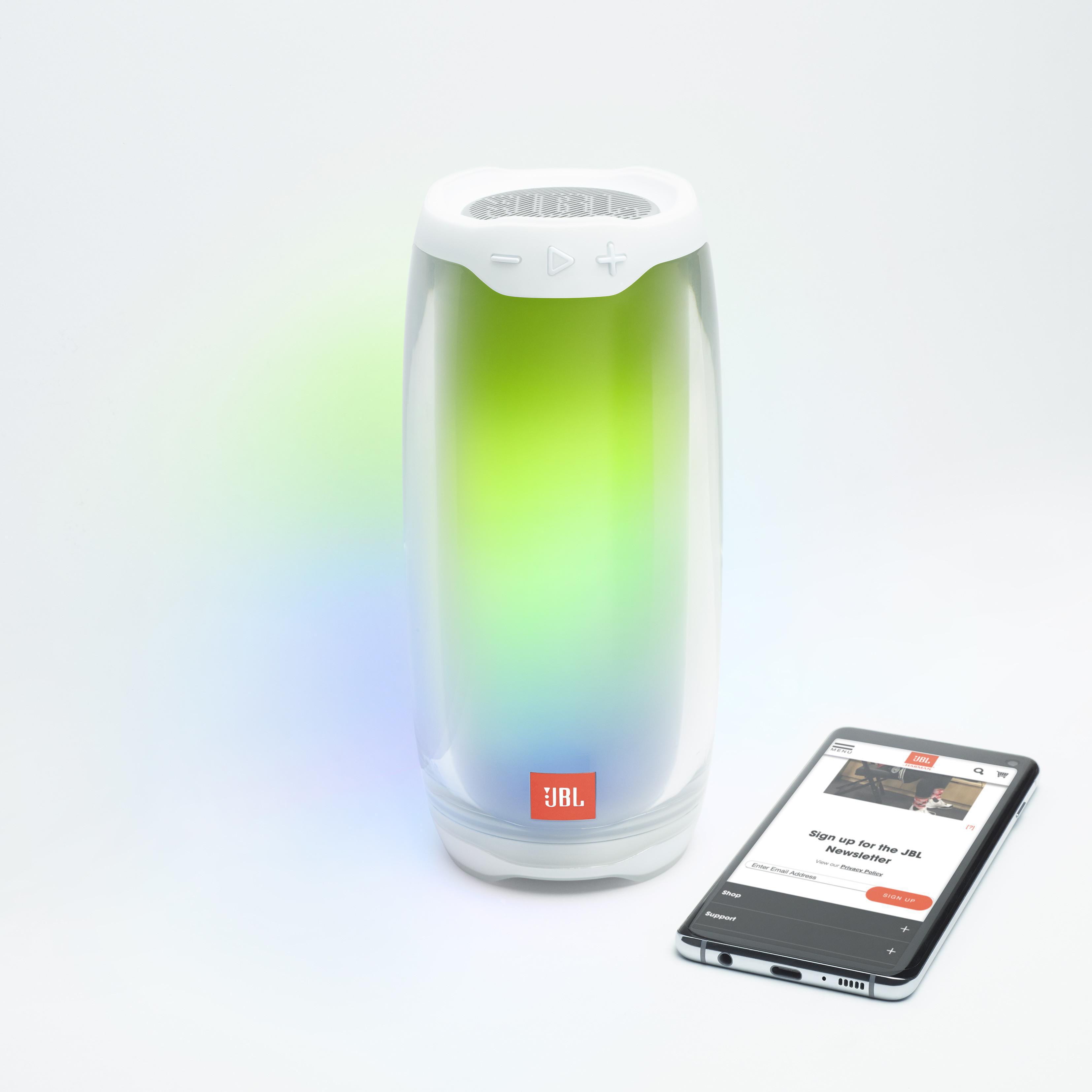 JBL-Lautsprecher mit farbigen Lichtern neben einem Telefon mit einem Anmeldeformular für den JBL-Newsletter.